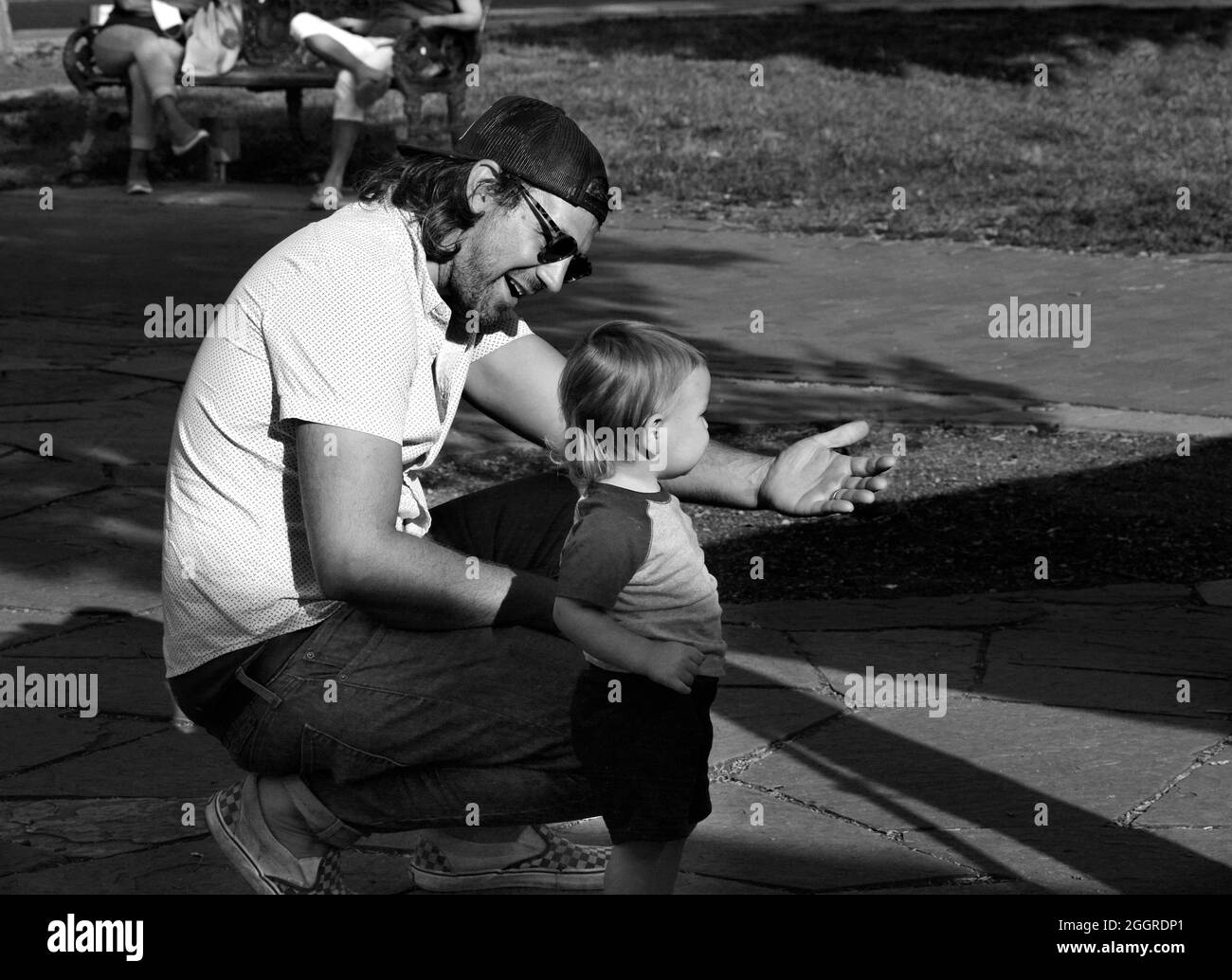 Un uomo e suo figlio si rilassano in un parco pubblico a Santa Fe, New Mexico. Foto Stock