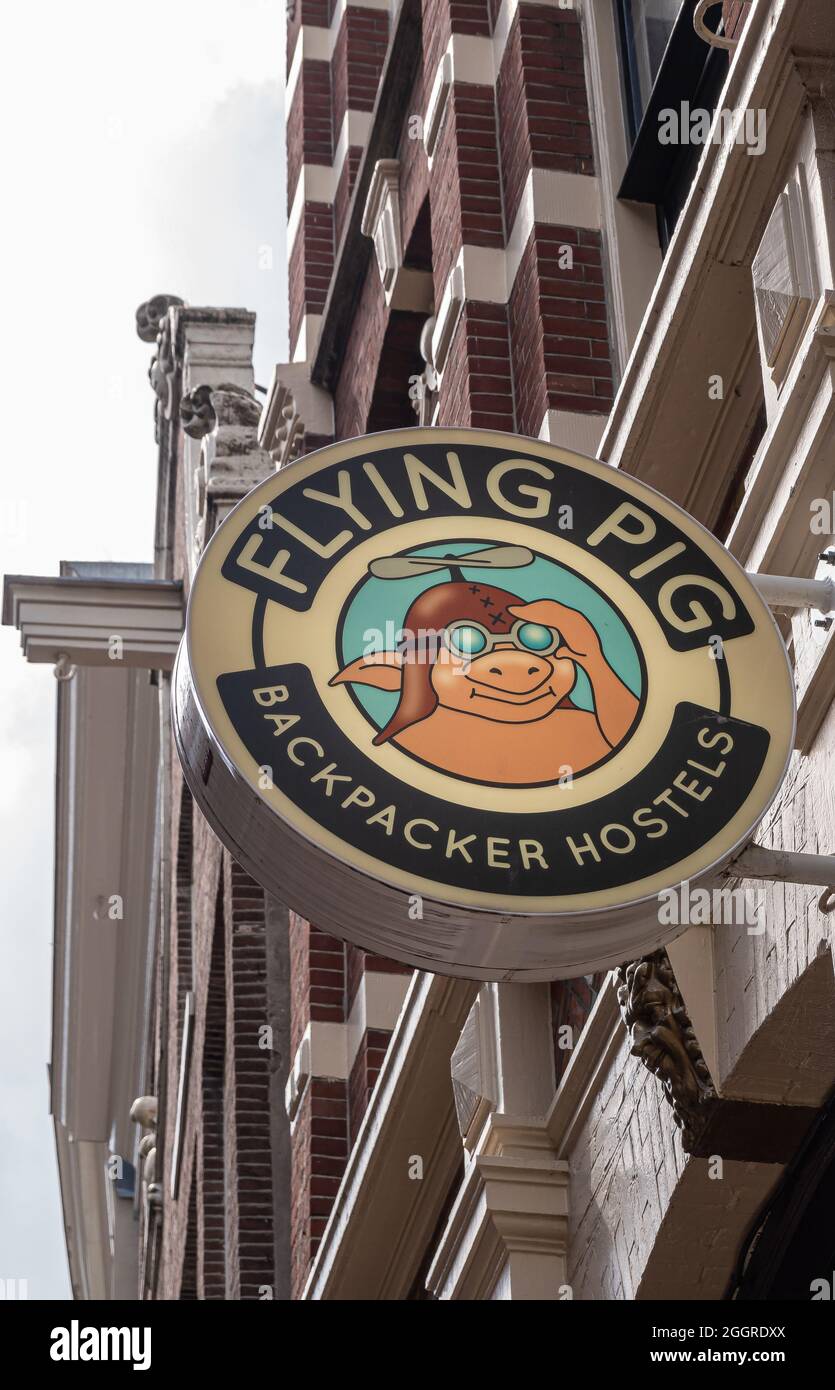 Amsterdam, Paesi Bassi - 14 agosto 2021: Primo piano di fuori segno colorato per Flying Pig Backpackers Hostels su Nieuwendijk. Facciata in pietra marrone e s. Foto Stock