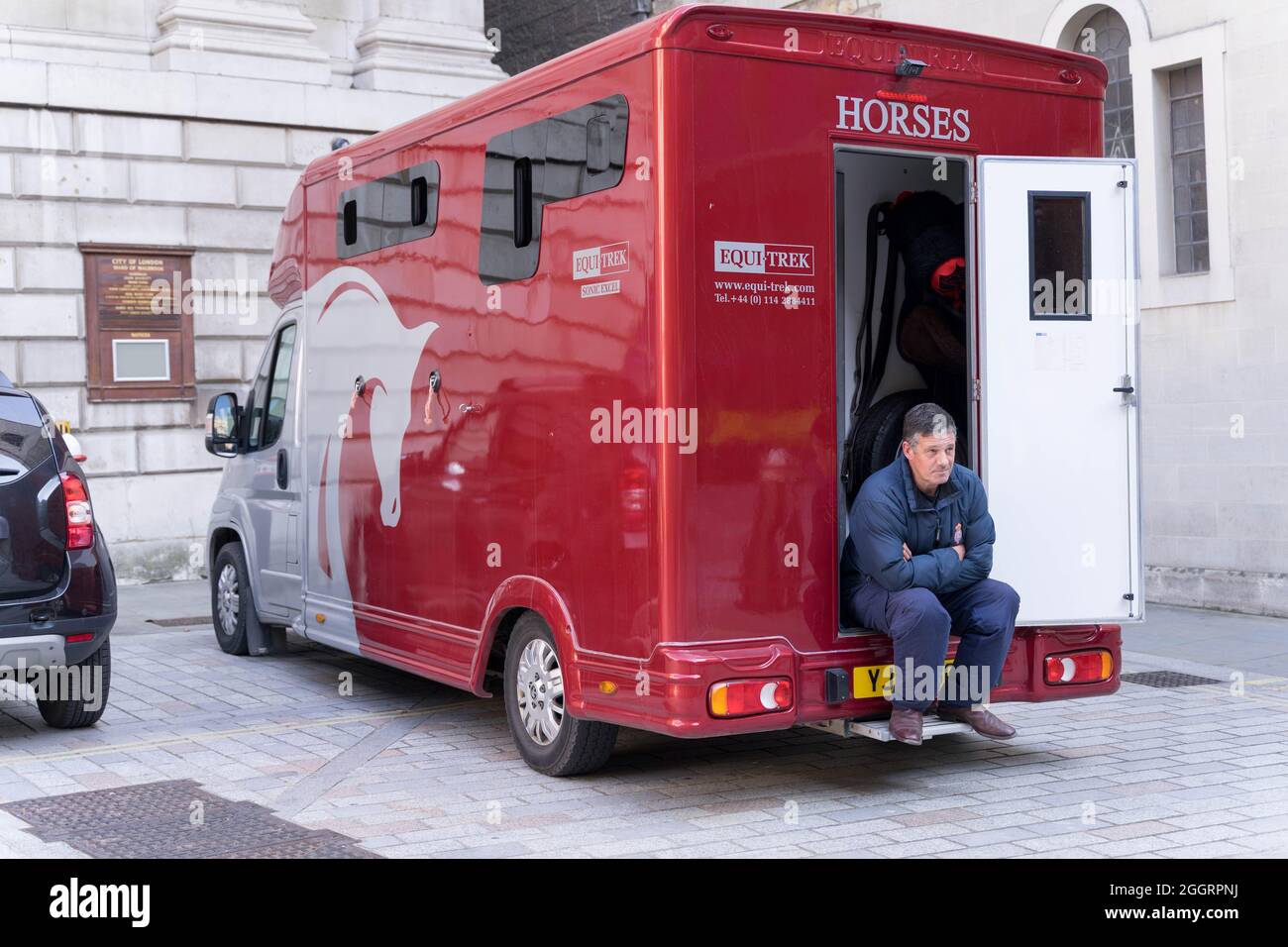 Furgone EquiTRek per cavallo, uomo seduto sul retro del carrello Foto Stock