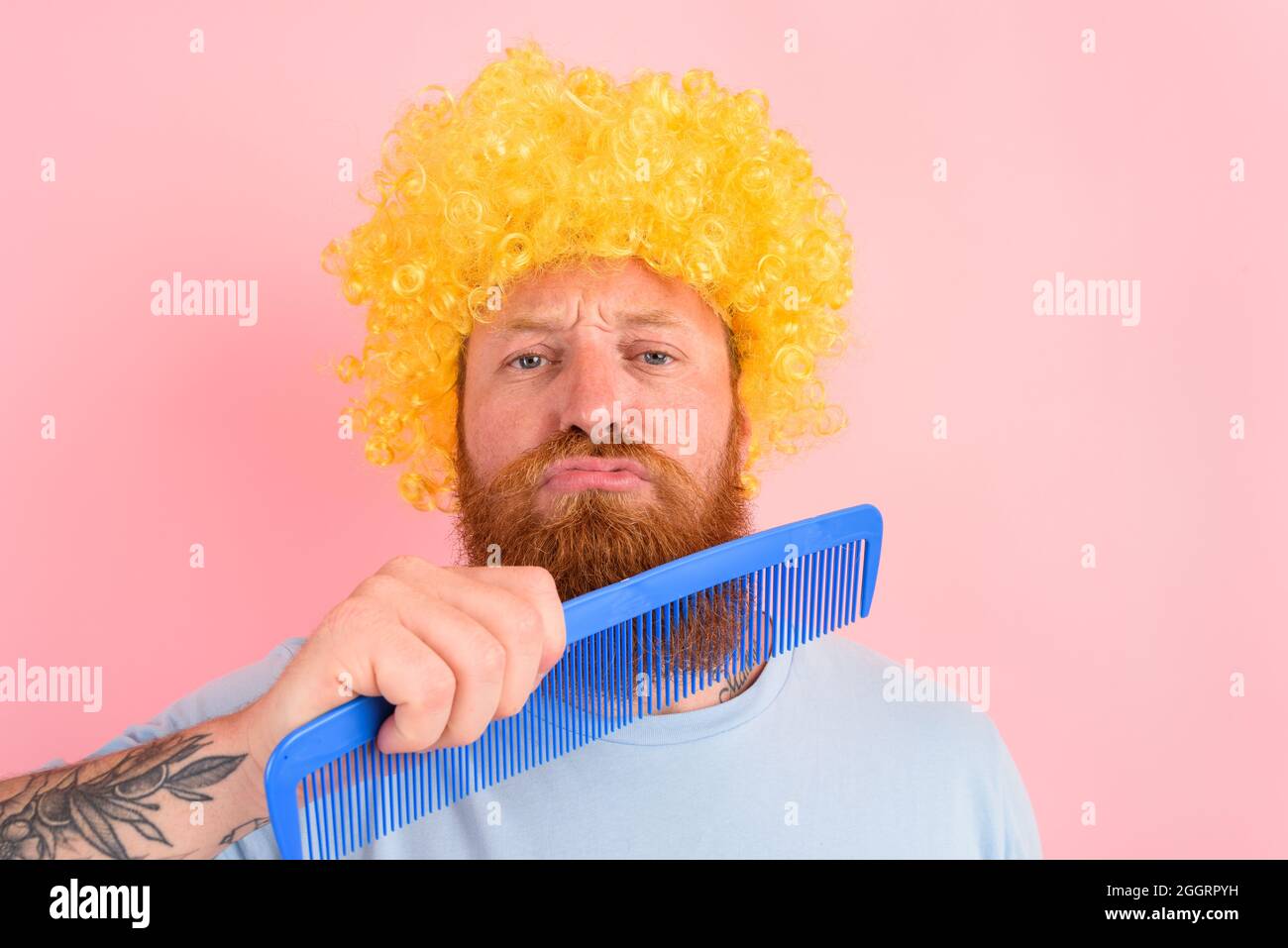 Uomo premuroso con barba, peruke giallo e pettine grande Foto Stock