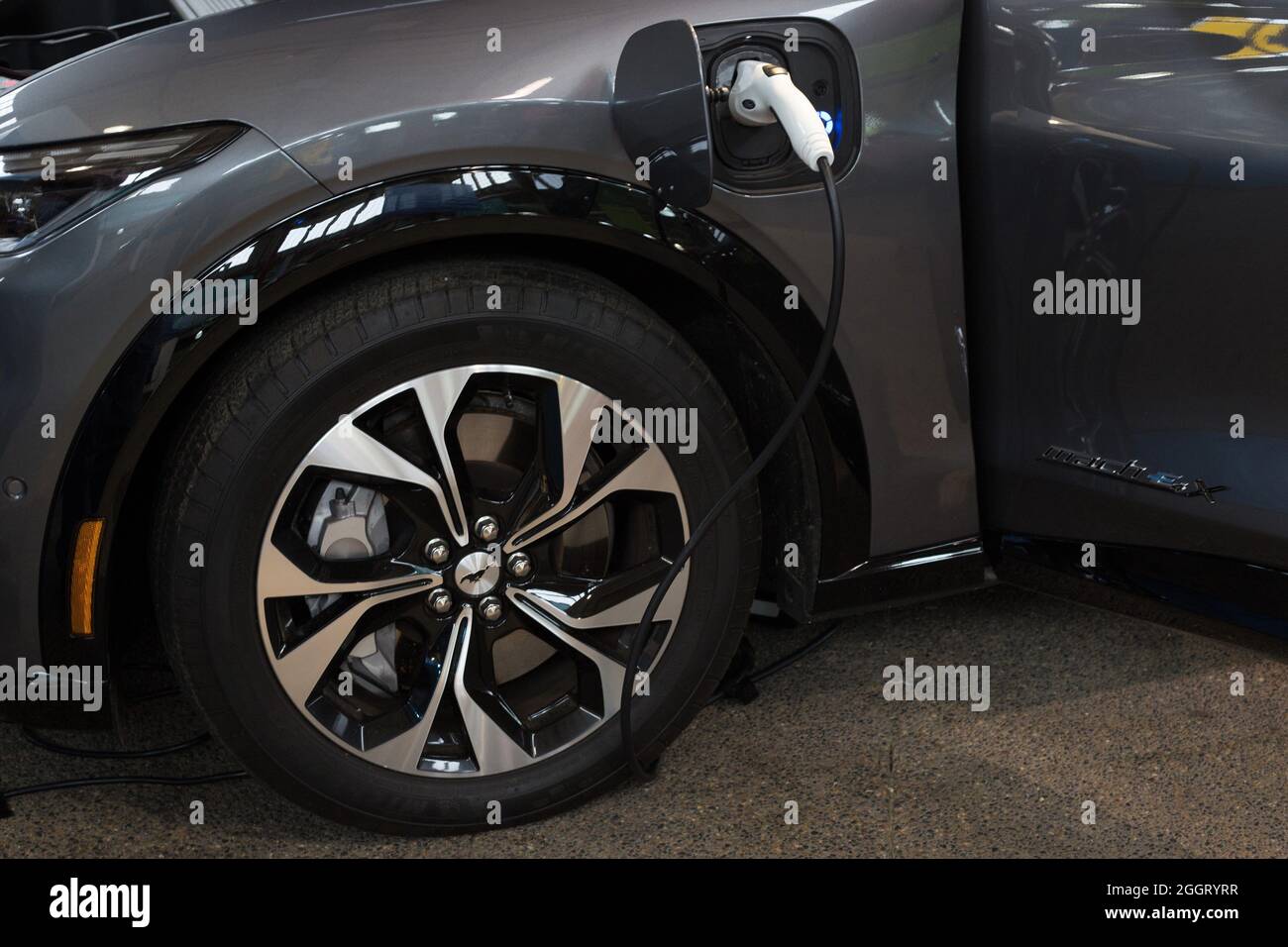 Un'auto elettrica in carica. Foto Stock