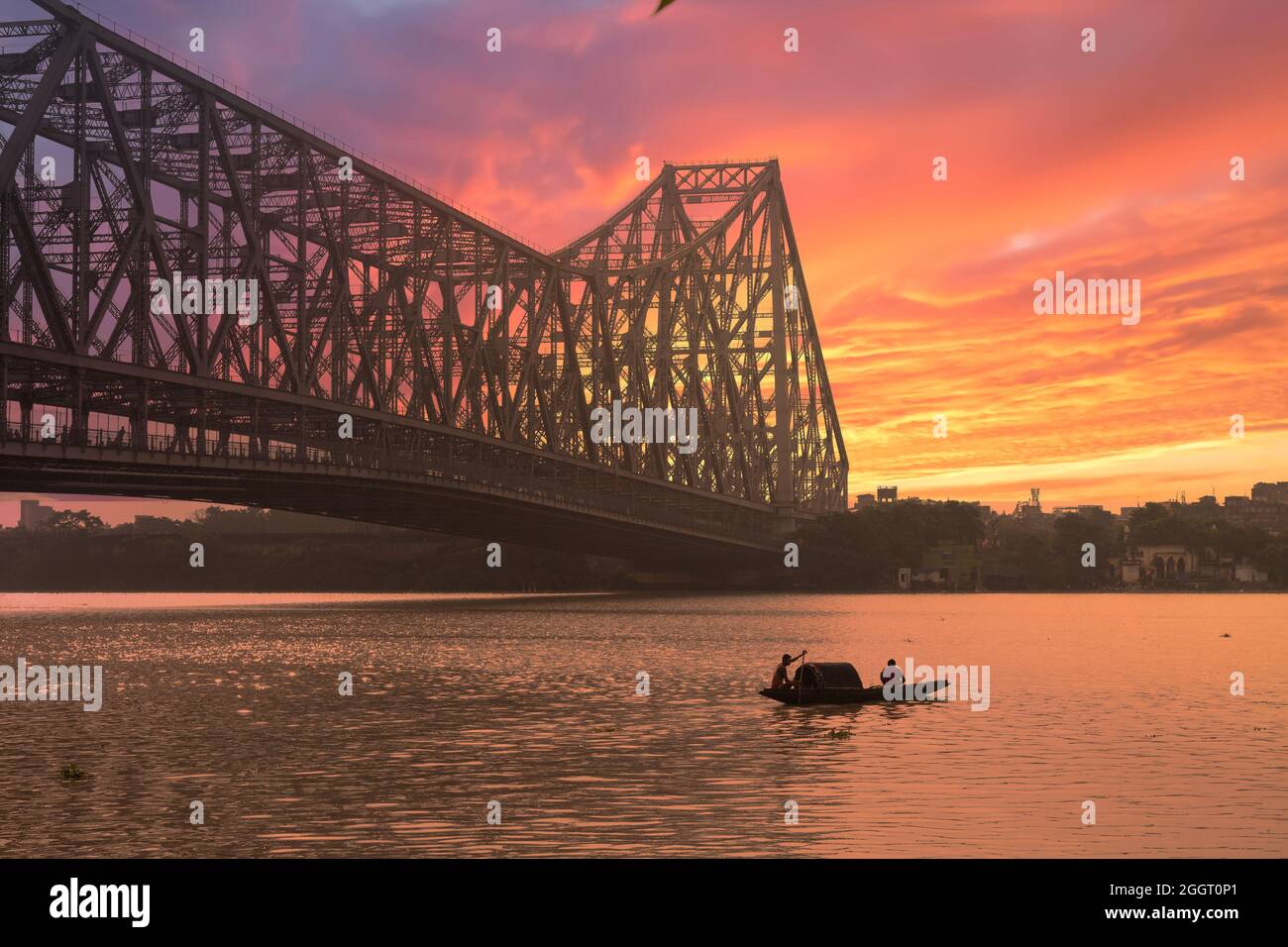 Ponte Howrah al tramonto con vista di una barca da pesca sul fiume Ganges e Kolkata paesaggio urbano Foto Stock