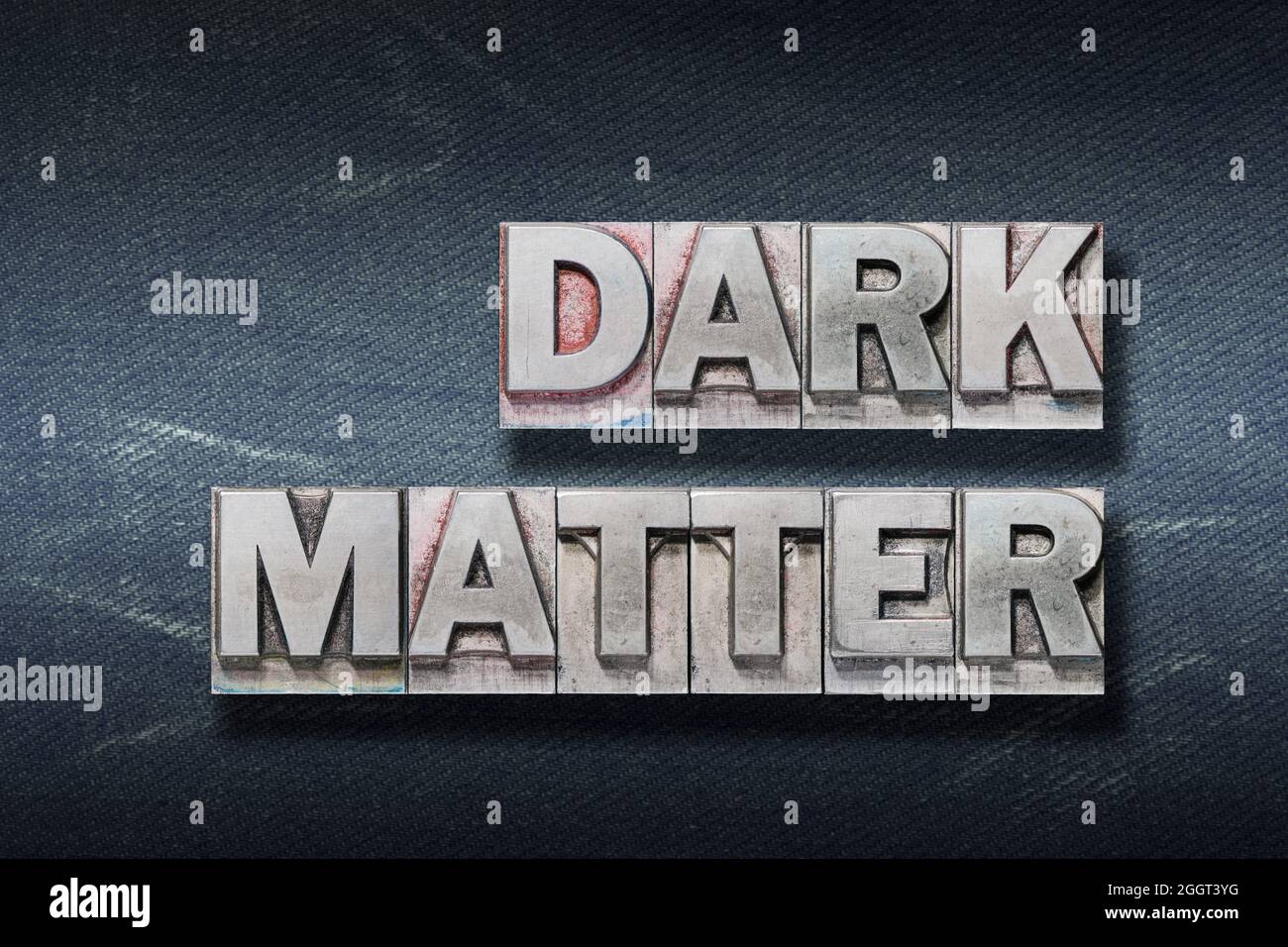 frase di materia scura realizzata con stampa di lettere metallizzata su sfondo di jeans scuri Foto Stock