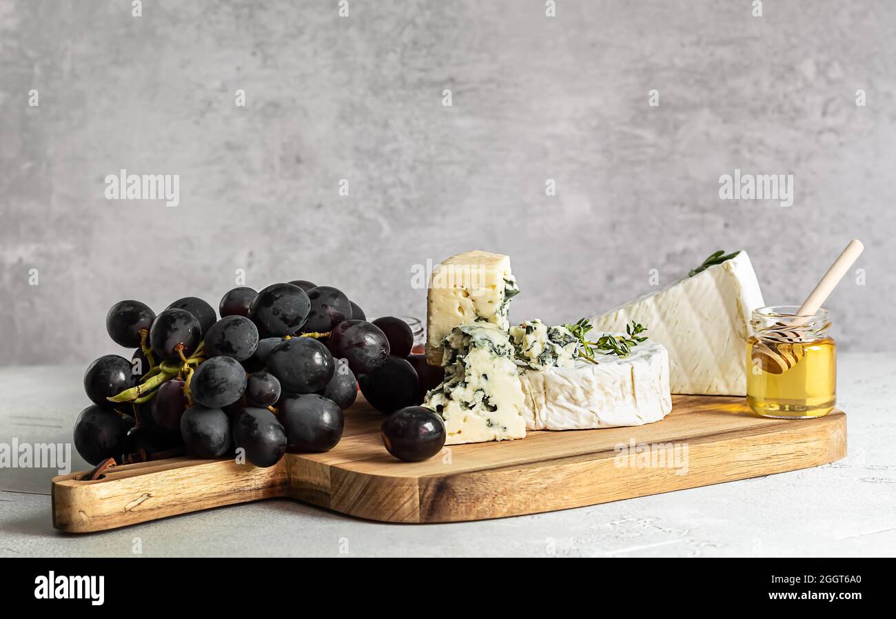Degustazione brie, camembert, e roquefort su un asse di legno. Foto Stock