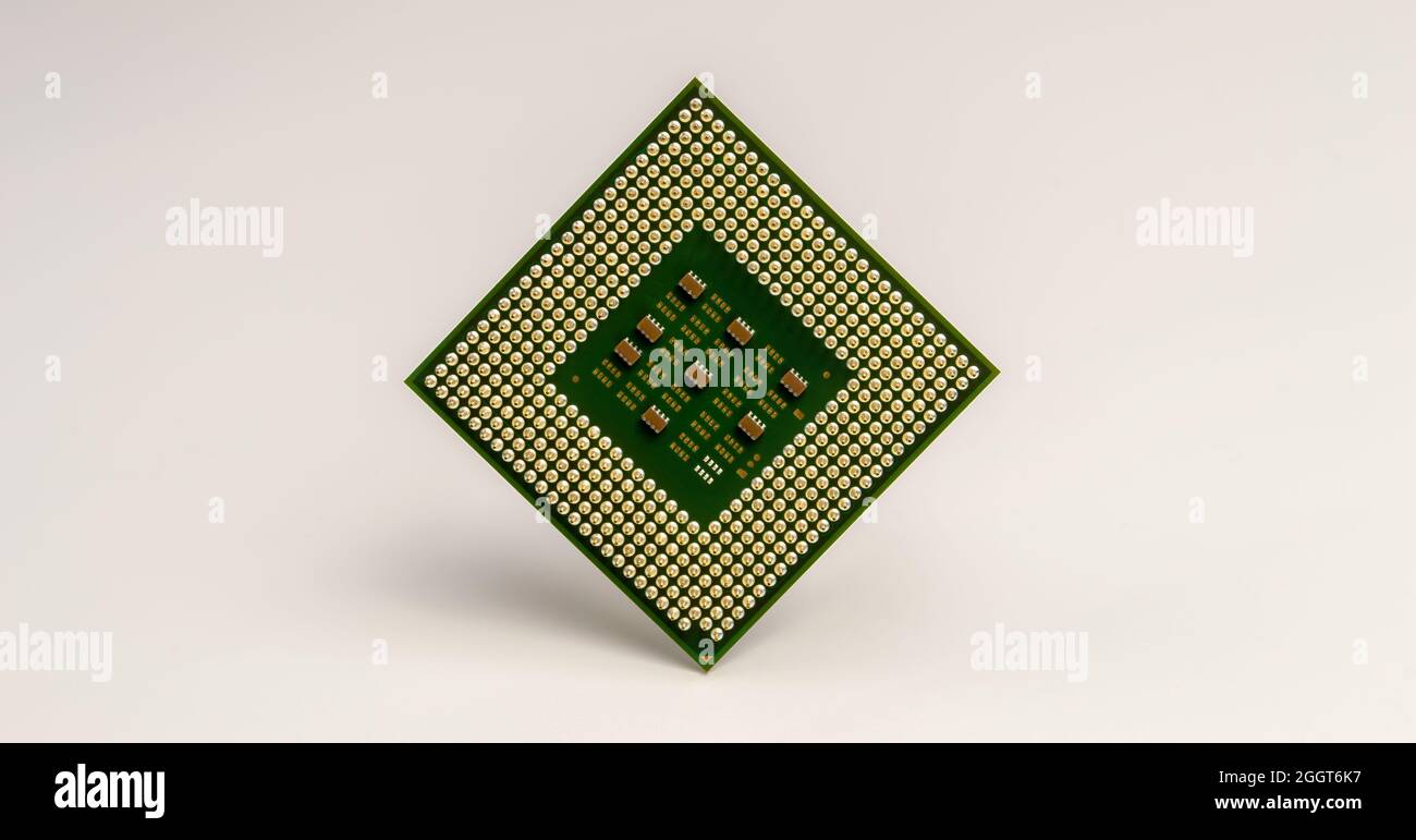 primo piano dell'unità processore centrale del computer con pin dorati su sfondo bianco Foto Stock