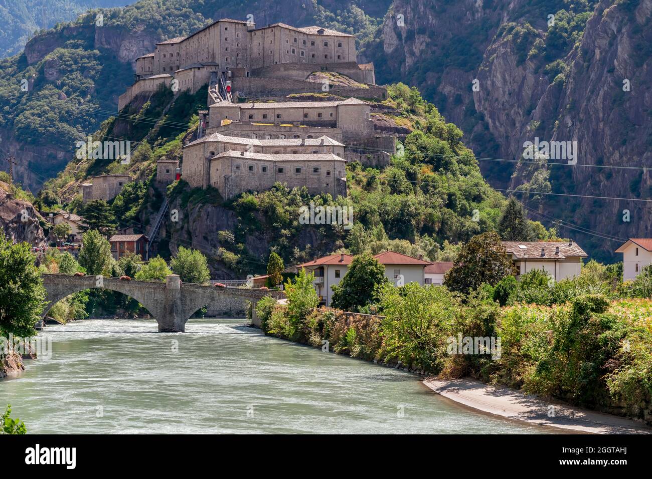 Il fiume Dora Baltea scorre sotto la collina del Forte di Bard, Valle d'Aosta, Italia Foto Stock