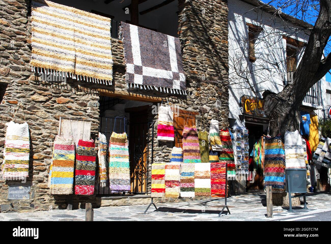 Negozio che vende tappeti fatti in loco nella città vecchia, Bubion, Spagna. Foto Stock