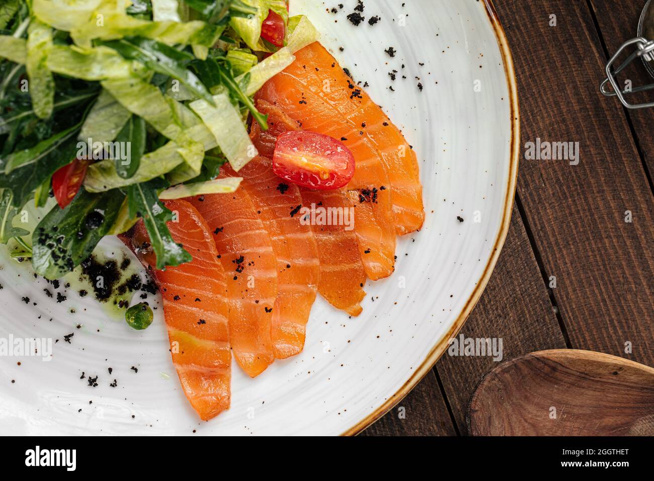 Piatto di salmone affettato salato e insalata verde Foto Stock