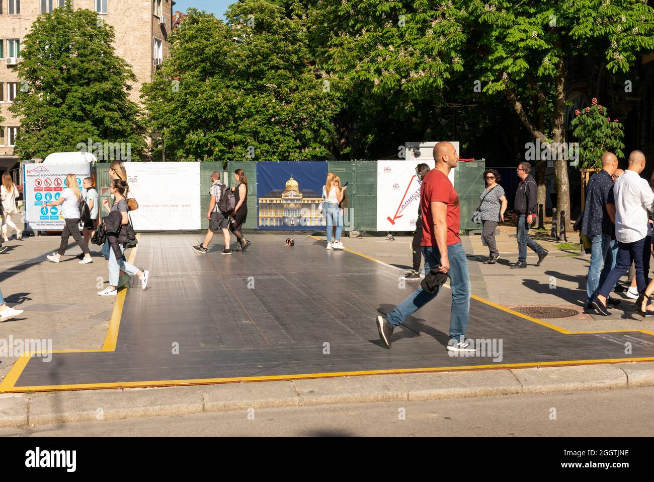 Persone che camminano su lamiera di acciaio inossidabile come protezione temporanea del battistrada sul marciapiede per cantieri edili in ambiente urbano, Sofia Bulgaria, UE Foto Stock