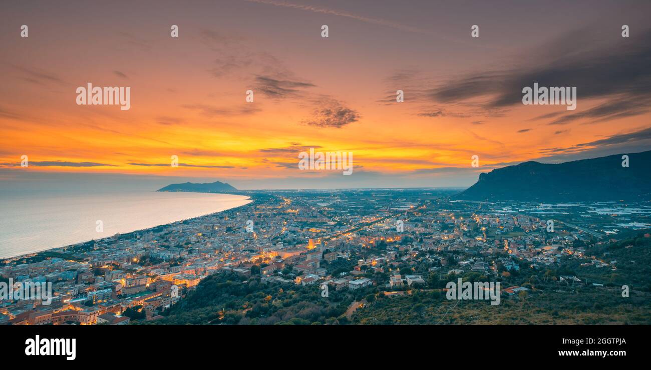 Terracina, Italia. Vista dall'alto skyline città in serata Tramonto. Illuminazioni cittadine Foto Stock