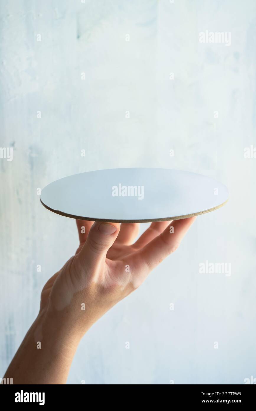 mano donna che tiene il piatto vuoto con il modello di prodotto di sfondo bianco con lo spazio per il testo e l'articolo Foto Stock