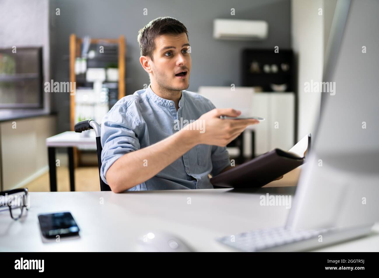 Assistente virtuale disabilitato in sedia a rotelle effettua videochiamata remota Foto Stock