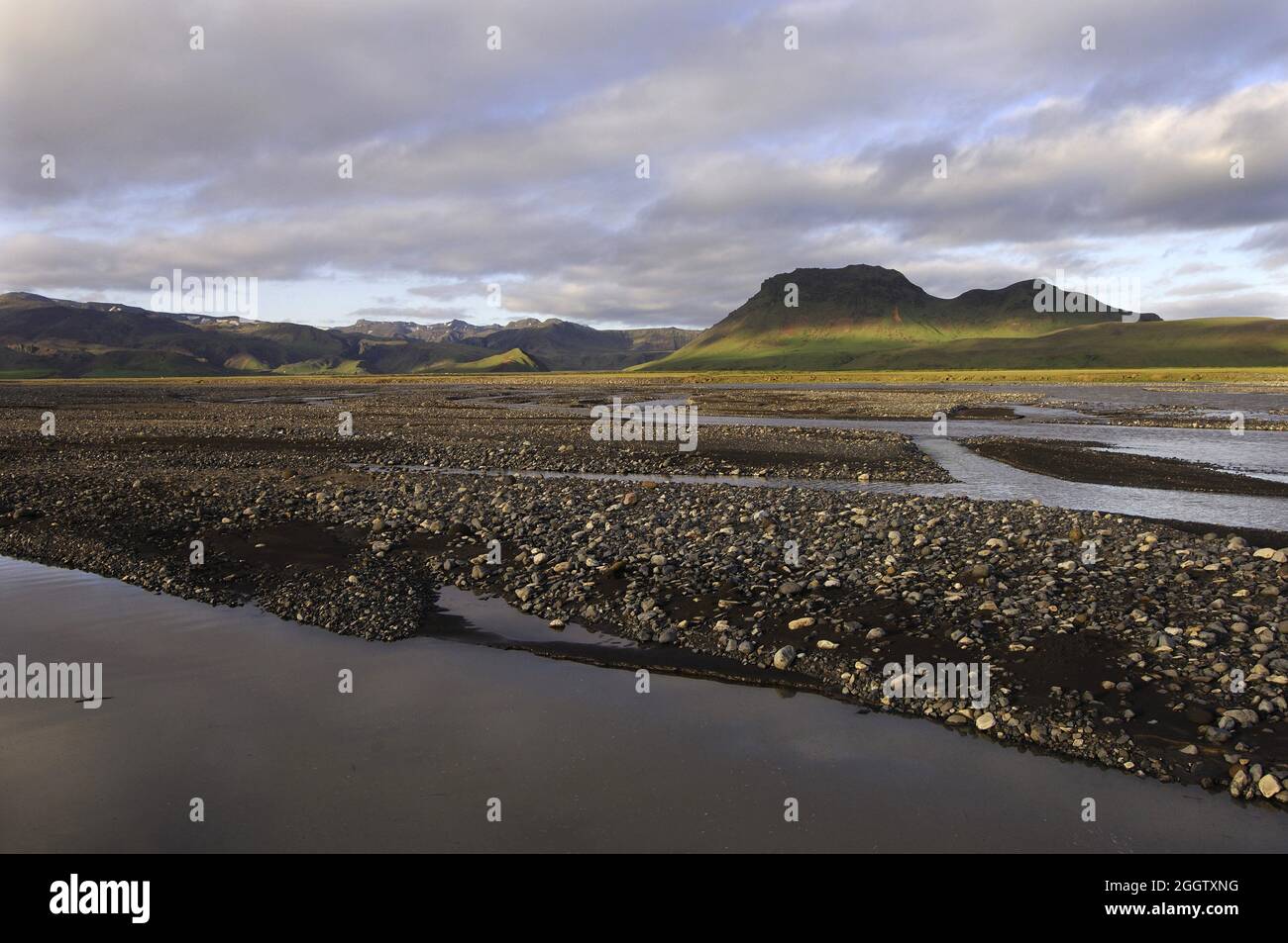 Luce notturna sulle trecce del fiume Sislalaekur, con luce applaiata su colline lontane, l'Islanda Foto Stock
