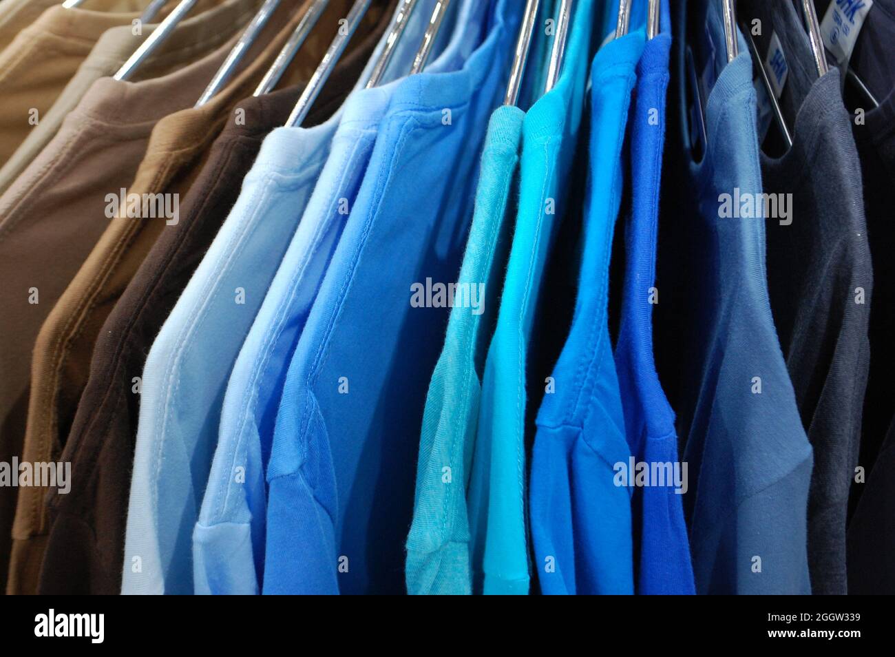 Rainbow vestiti colorati su appendiabiti in un negozio di vendita al dettaglio. La moda e lo shopping concept Foto Stock