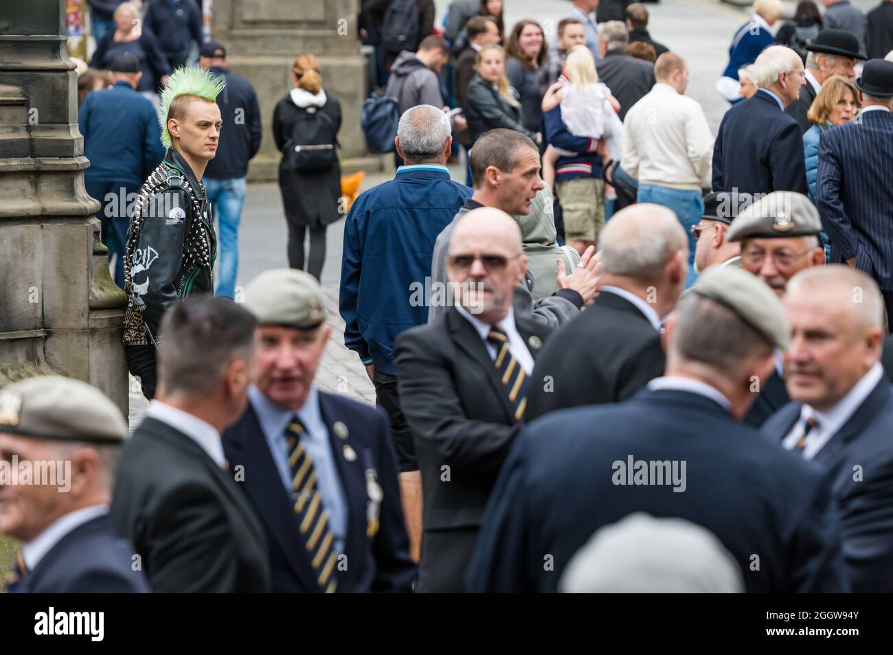 Royal Mile, Edimburgo, Scozia, Regno Unito, 3rd settembre 2021. Royal Scots Dragoon Guards Parade: La sfilata accompagnata dai loro tubi e tamburi e montato cavalli grigi per celebrare il 50th anniversario della loro amalgamazione (fuso nel 1971 dai Royal Scots Grays e dai 3rd moschettoni). Nella foto: I veterani si riuniscono in Piazza del Parlamento e si riuniscono prima di unirsi alla sfilata con un giovane uomo con uno stile punk hair Foto Stock