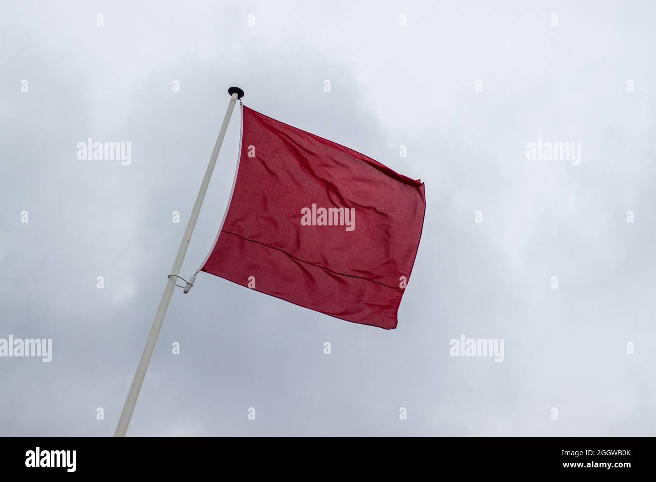 Una bandiera rossa lungo la costa olandese che indica che è vietato nuotare nell'oceano (Kijkduin, l'Aia, Paesi Bassi) Foto Stock