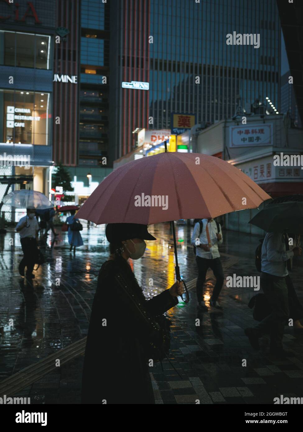 Una donna che indossa una maschera protettiva per il viso tiene un ombrello il 3 settembre 2021 a Tokyo, Giappone. Il Giappone è sotto una quinta ondata di convivi19 con la variante delta. 03 settembre 2021 Credit: Nicolas Datiche/AFLO/Alamy Live News Foto Stock