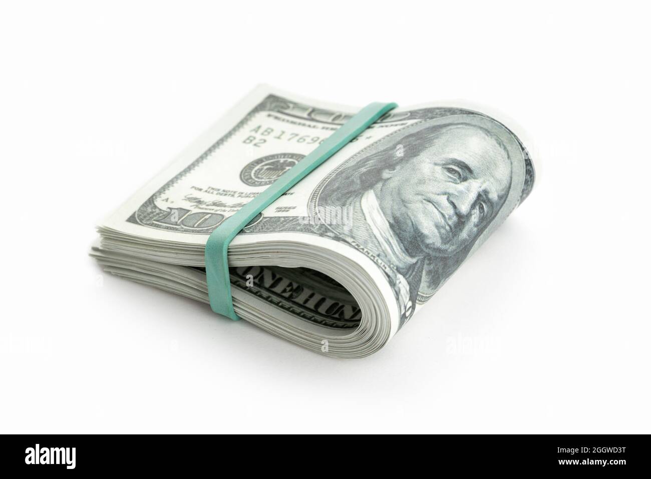 Pila di denaro piegata a metà sotto la fascia elastica isolata su sfondo bianco. Bollette in dollari USA. Spazio di copia Foto Stock