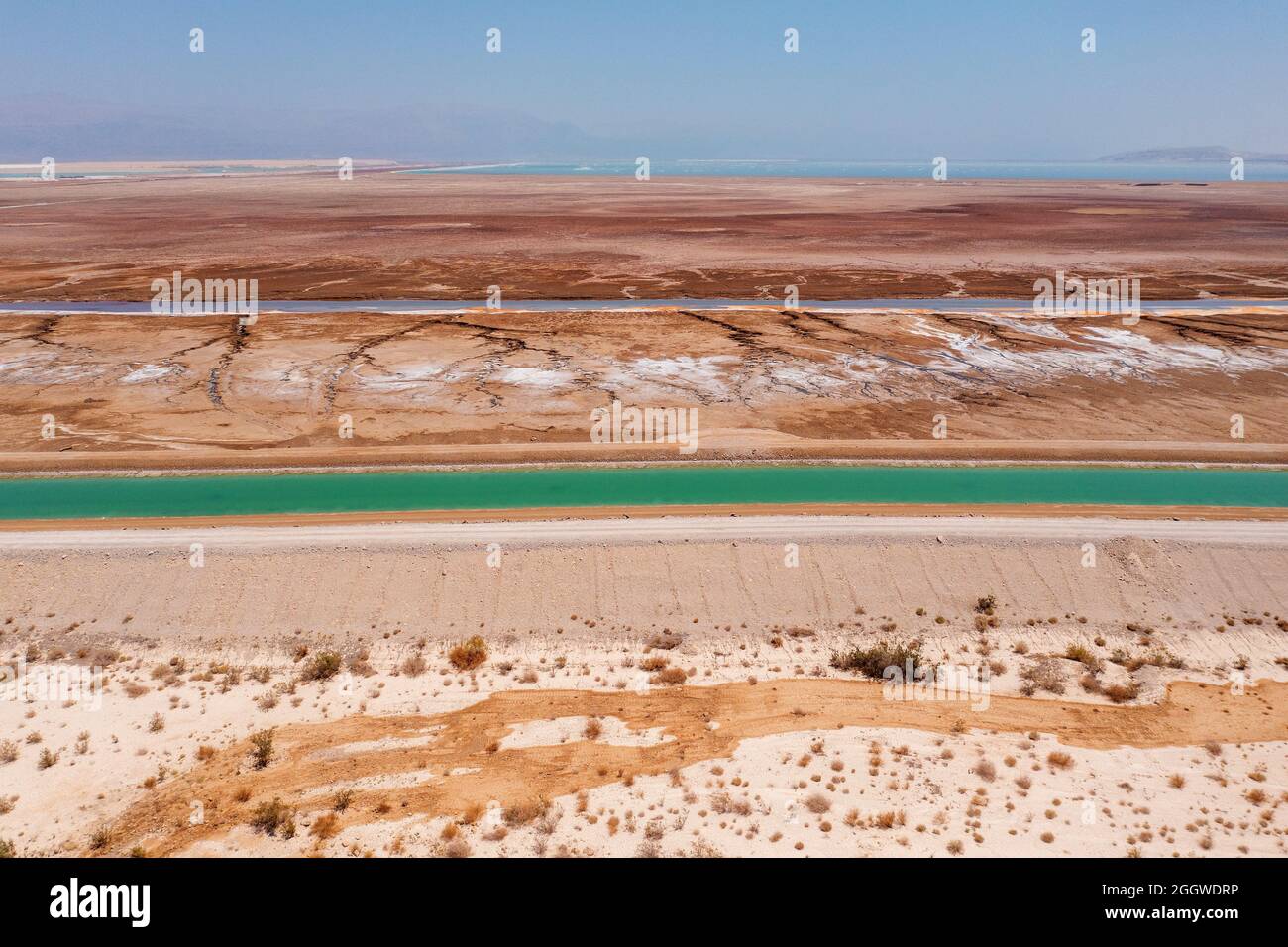 Canale di acqua salata che conduce l'acqua del Mar Morto alle piscine di evaporazione, vista aerea. Foto Stock