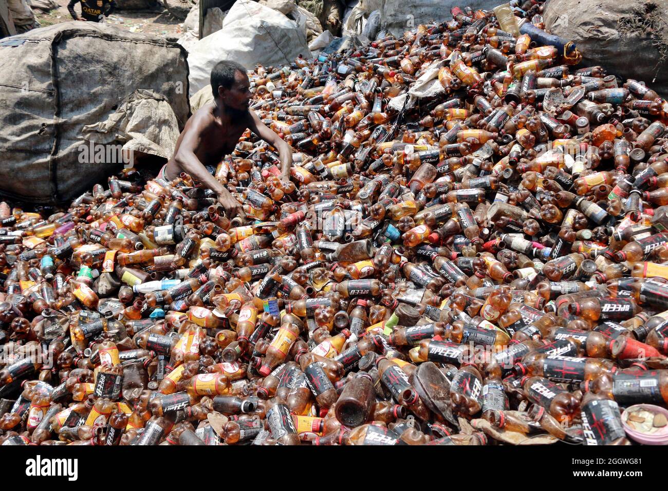 Dhaka, Bangladesh, 03/09/2021, Un uomo separa bottiglie di polietilene tereftalato (PET) in una fabbrica di riciclaggio alla periferia di Dhaka. Il riciclaggio delle bottiglie in plastica è diventato un'attività in crescita negli ultimi due anni e contribuisce a proteggere l'ambiente. Secondo la Bangladesh PET Flakes Manufacturers and Exporters Association (BPFMEA), il Bangladesh esporta in media quasi 30,000 tonnellate di fiocchi di bottiglie di PET principalmente in Cina, Corea del Sud e Taiwan per un valore di 14 milioni di dollari l'anno. Il 3 settembre 2021. (Foto di Habibur Rahman / Eyepix Group) Foto Stock