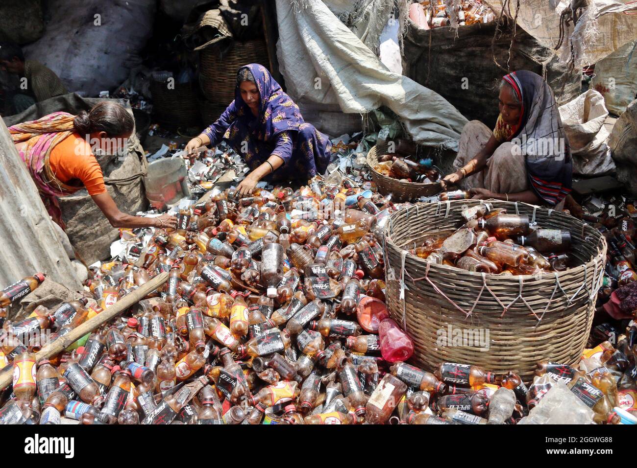Dhaka, Bangladesh, 03/09/2021, le lavoratrici separano bottiglie di polietilene tereftalato (PET) in una fabbrica di riciclaggio alla periferia di Dhaka. Il riciclaggio delle bottiglie in plastica è diventato un'attività in crescita negli ultimi due anni e contribuisce a proteggere l'ambiente. Secondo la Bangladesh PET Flakes Manufacturers and Exporters Association (BPFMEA), il Bangladesh esporta in media quasi 30,000 tonnellate di fiocchi di bottiglie di PET principalmente in Cina, Corea del Sud e Taiwan per un valore di 14 milioni di dollari l'anno. Il 3 settembre 2021. (Foto di Habibur Rahman / Eyepix Group) Foto Stock