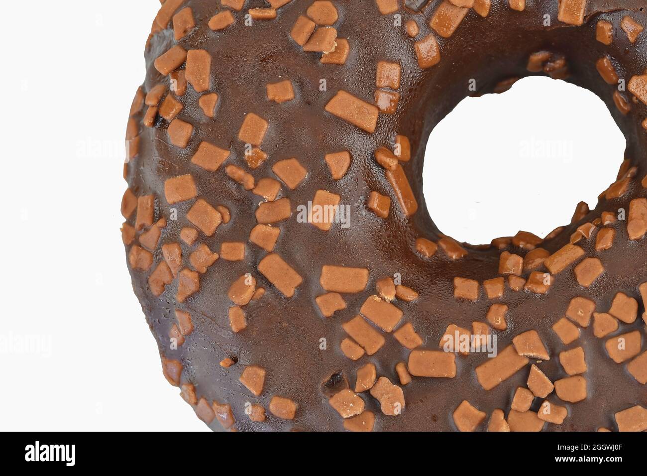 Ciambella al cioccolato con spolverini su sfondo bianco. Zucchero, dolci, snack, cibo spazzatura concetto. Vista dall'alto. Spazio per il testo. Disposizione piatta. Foto Stock