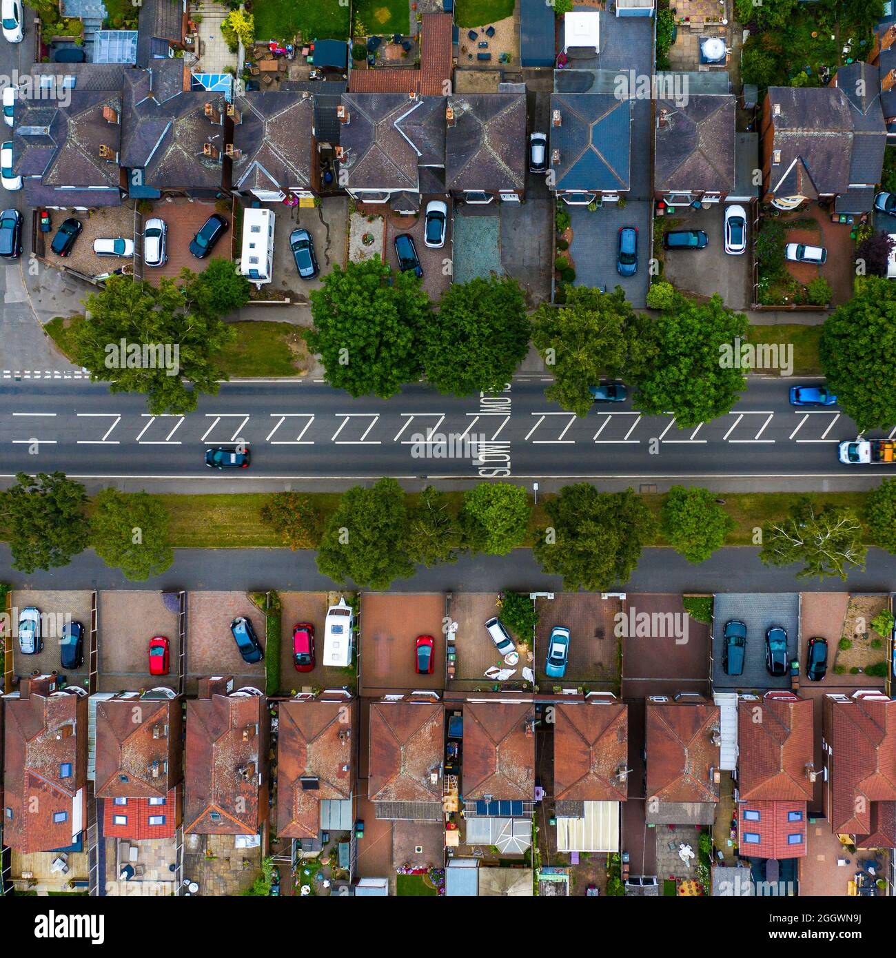 Una vista aerea di un quartiere suburbano a maglia stretta nel Regno Unito con una strada trafficata che passa attraverso Foto Stock