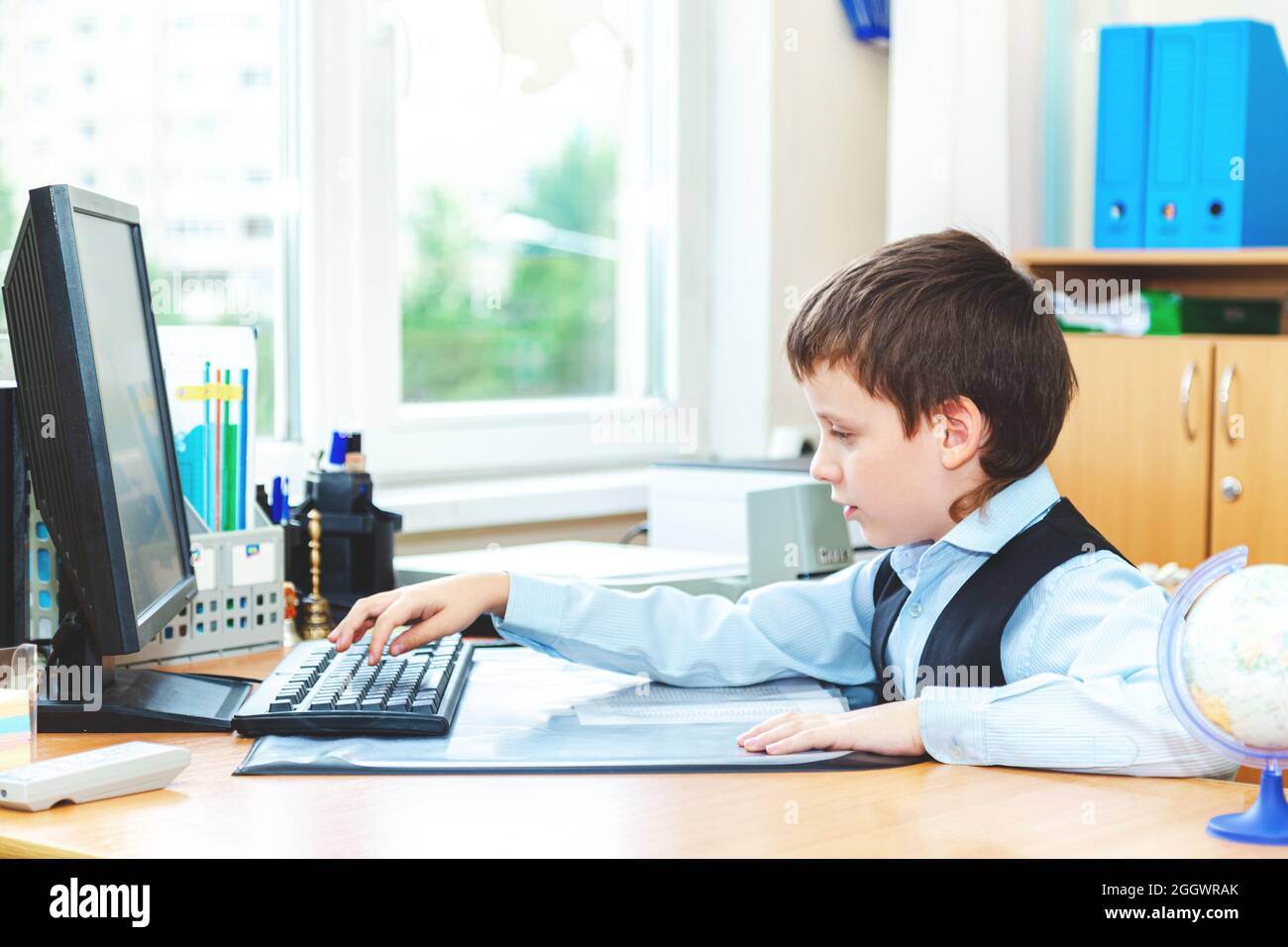 Scolaro serio in classe. Studente della scuola elementare. Ritorno a scuola. Foto Stock