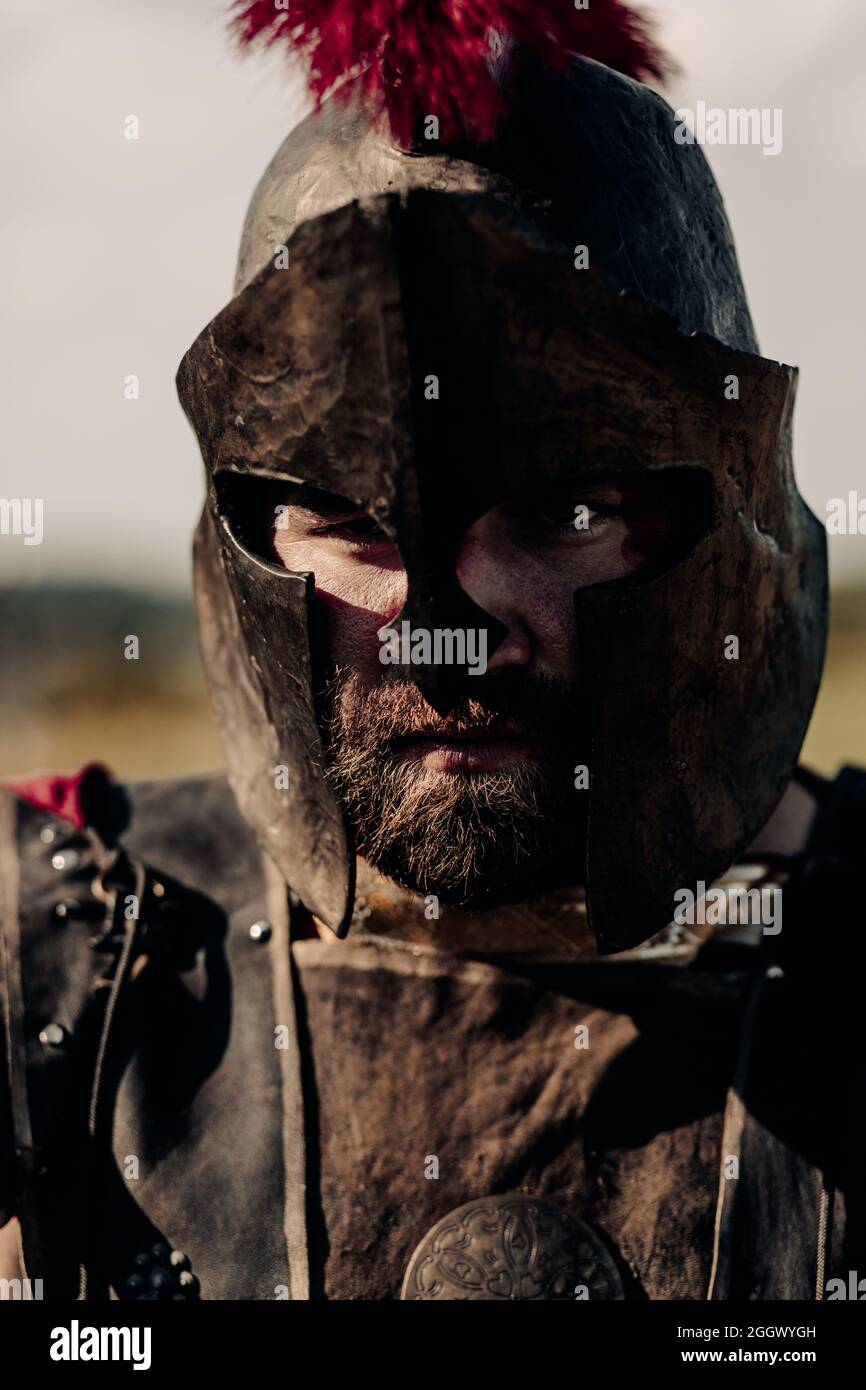 Ritratto dell'antico guerriero spartano in armatura, casco e maschera. Foto Stock