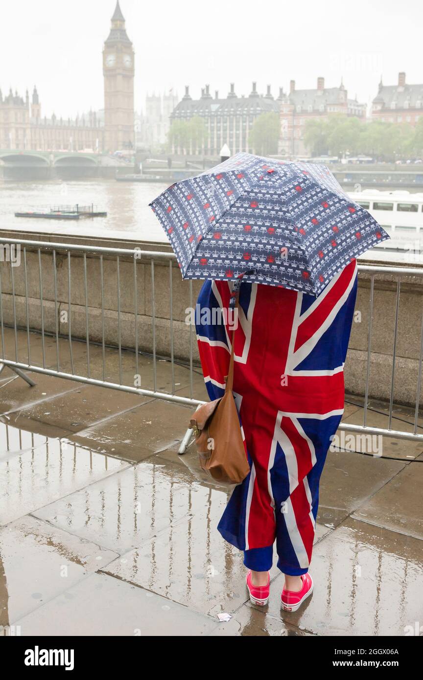 Uno spettatore solista che attende sotto la pioggia per il Tamigi Diamond Jubilee Pageant per passare la South Bank, Londra. Il Pageant era composto da centinaia di barche che navigavano dal ponte di Battersea al ponte della Torre per celebrare i 60 anni della regina Elisabetta II sul trono. Milioni di persone hanno fiancheggiato le rive del Tamigi per guardare lo spettacolo. South Bank, Londra, Regno Unito. 3 Giu 2012 Foto Stock