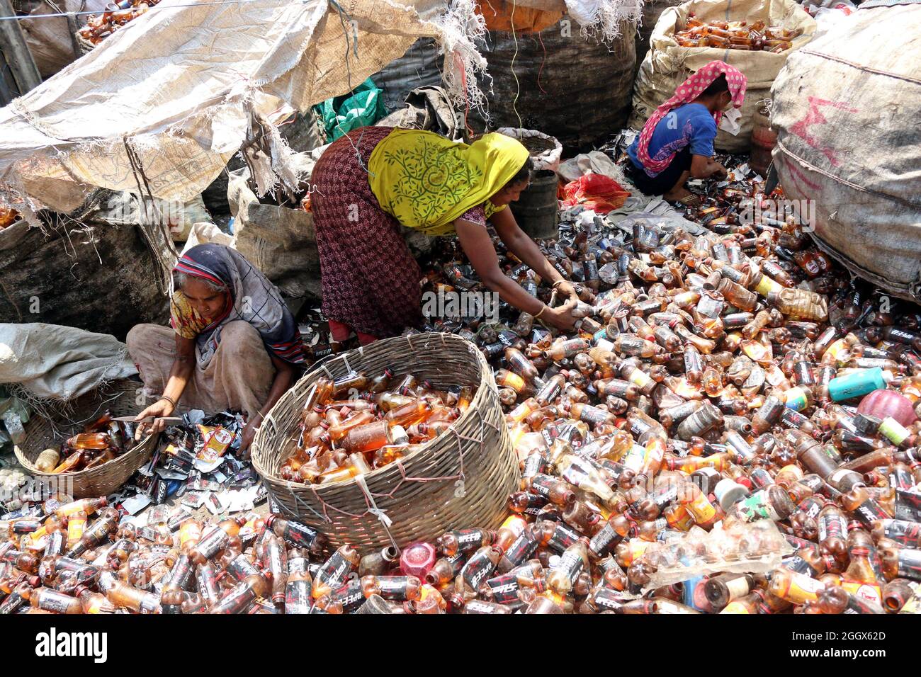 Non esclusiva: DHAKA, BANGLADESH -3 SETTEMBRE: Le donne lavoratrici separano bottiglie di polietilene tereftalato (PET) in una fabbrica di riciclaggio all'esterno Foto Stock