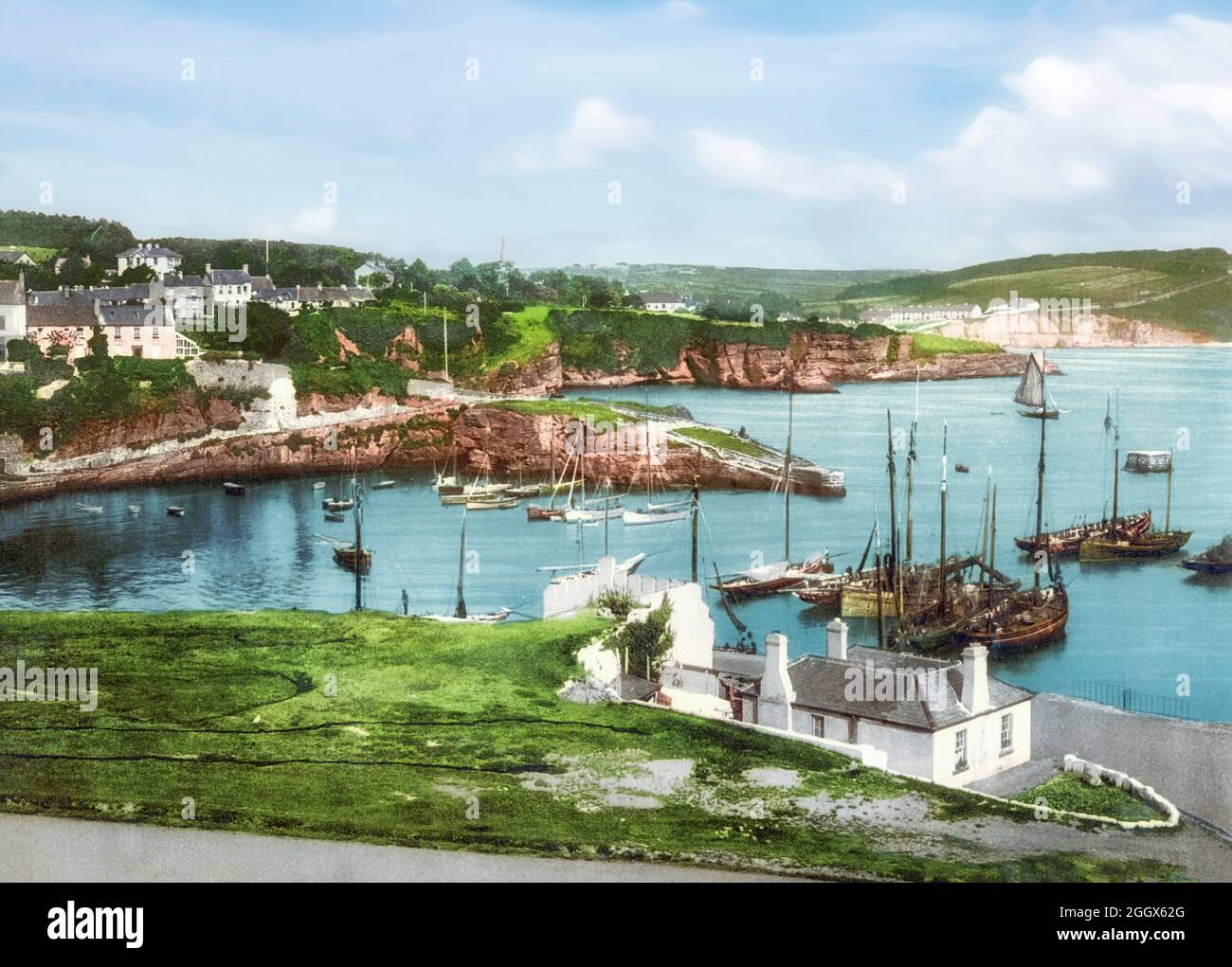 Una vista dei primi del 20 ° secolo di Dunmore East, un popolare villaggio turistico e di pescatori nella contea di Waterford, Irlanda. Situato sul lato ovest del porto di Waterford, sulla costa sud-orientale dell'Irlanda, si trova all'interno della baronia di Gaultier (Gáll Tír – terra 'straniera' in irlandese), un riferimento all'afflusso di coloni vichinghi e normanni nella zona. Foto Stock