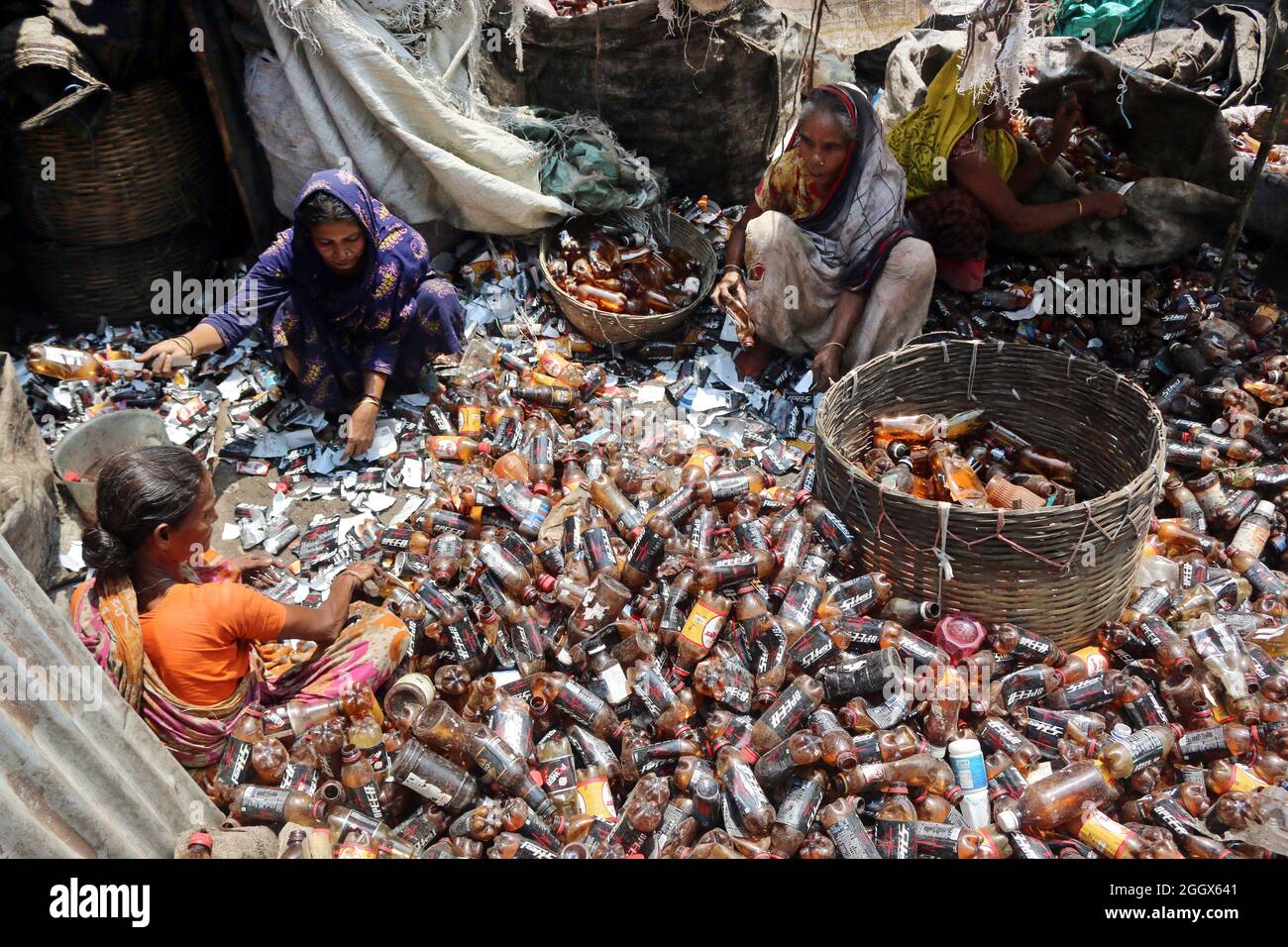 Non esclusiva: DHAKA, BANGLADESH -3 SETTEMBRE: Le donne lavoratrici separano bottiglie di polietilene tereftalato (PET) in una fabbrica di riciclaggio all'esterno Foto Stock