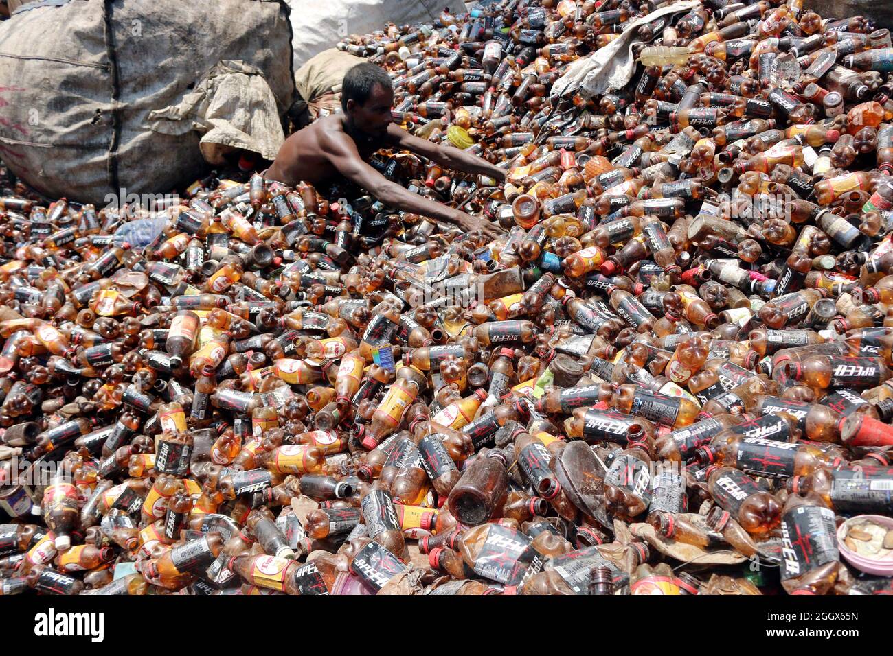 Non esclusiva: DHAKA, BANGLADESH -3 SETTEMBRE: Un uomo separa le bottiglie di polietilene tereftalato (PET) in una fabbrica di riciclaggio alla periferia di D. Foto Stock
