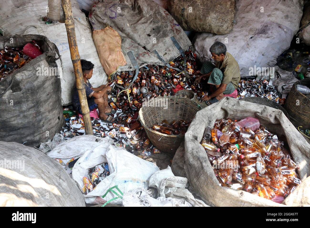 Non esclusiva: DHAKA, BANGLADESH -3 SETTEMBRE: Un uomo separa le bottiglie di polietilene tereftalato (PET) in una fabbrica di riciclaggio alla periferia di D. Foto Stock