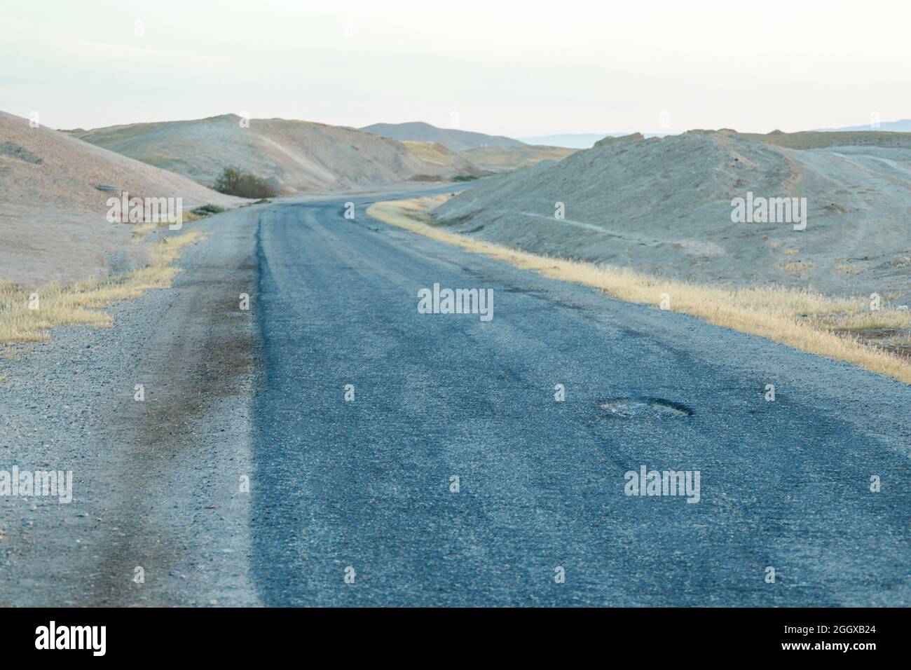Calcestruzzo fessurato su strada deserta. Strada asfaltata. Foto Stock