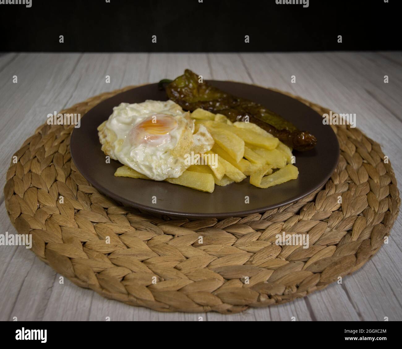 Patate fritte con uova fritte e pepe fritto, un alimento molto richiesto nel sud della Spagna. Le patate non devono essere congelate e tutte fatte in casa. Foto Stock