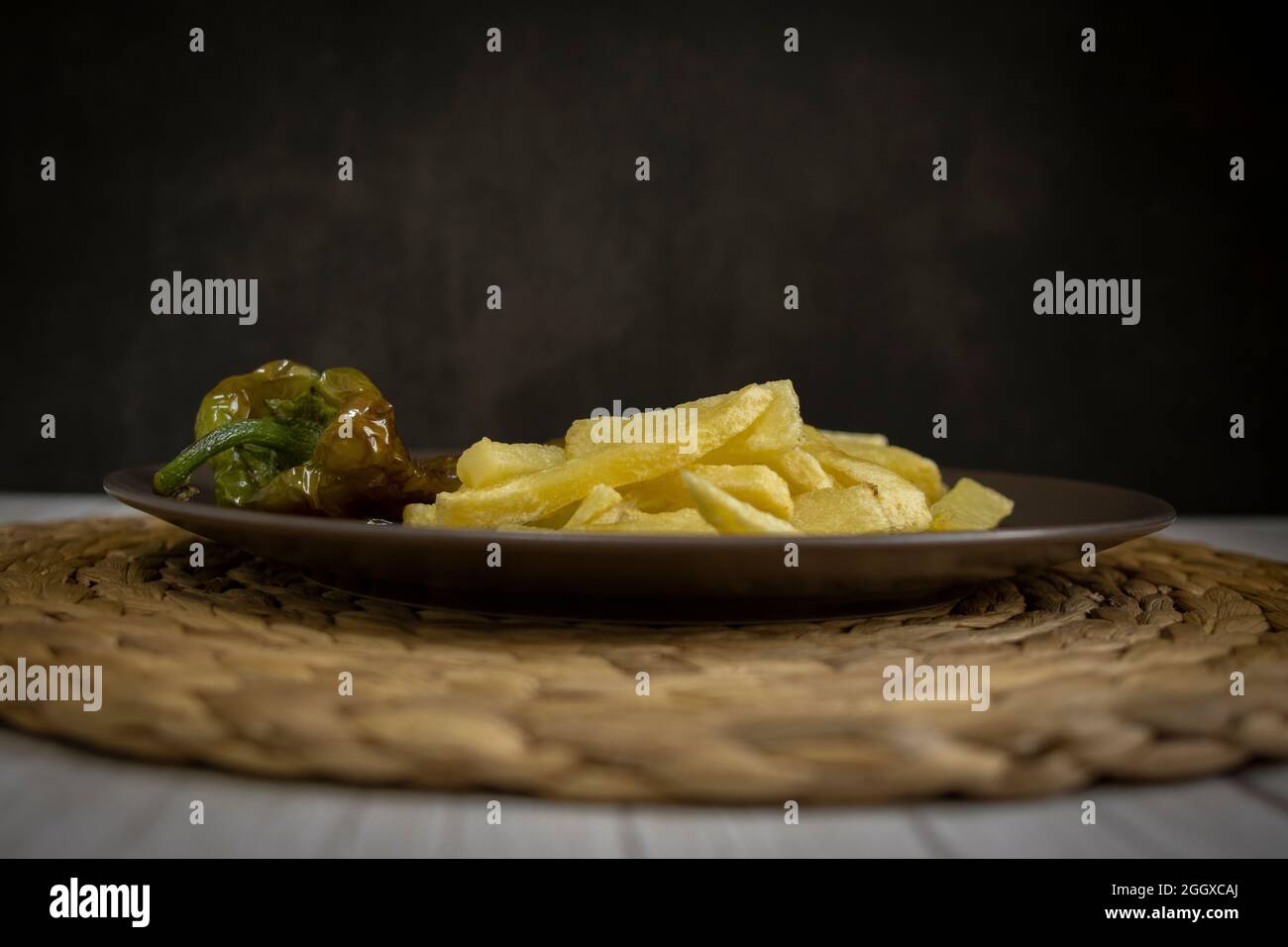 Patatine fritte con peperoni fritti, un alimento molto popolare nel sud della Spagna. Le patate non devono essere congelate e tutte fatte in casa. Tutto fatto con olio d'oliva. Foto Stock