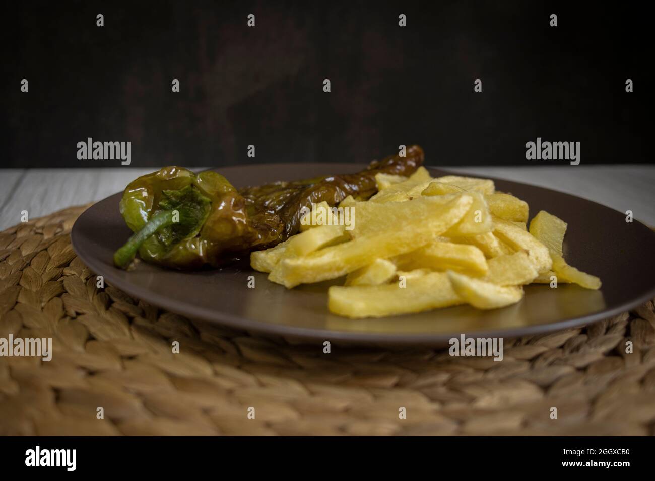 Patatine fritte con peperoni fritti, un alimento molto popolare nel sud della Spagna. Le patate non devono essere congelate e tutte fatte in casa. Tutto fatto con olio d'oliva. Foto Stock