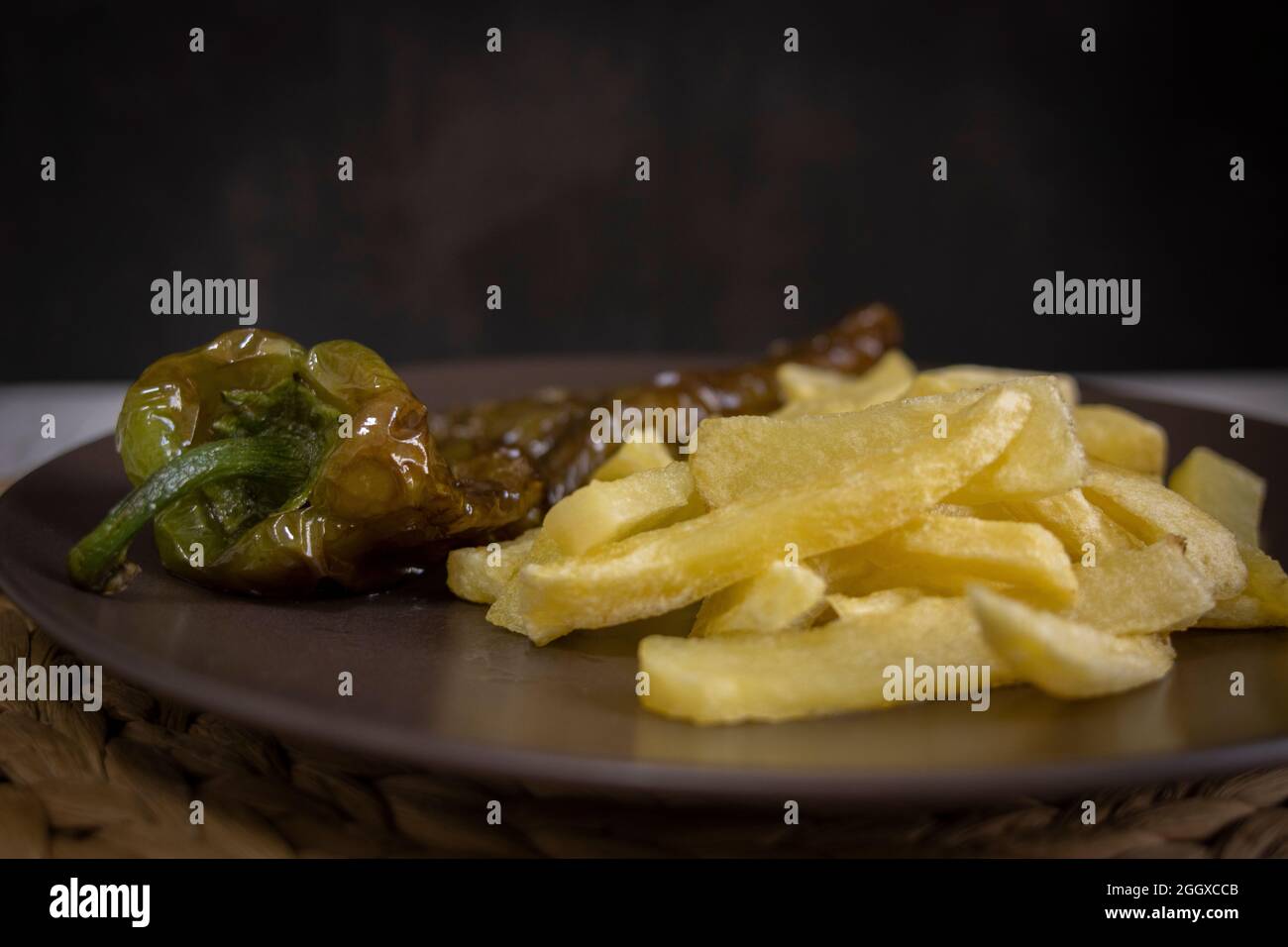 Patatine fritte con peperoni fritti, un alimento molto popolare nel sud della Spagna. Le patate non devono essere congelate e tutte fatte in casa. Tutto fatto con olio d'oliva. Foto Stock