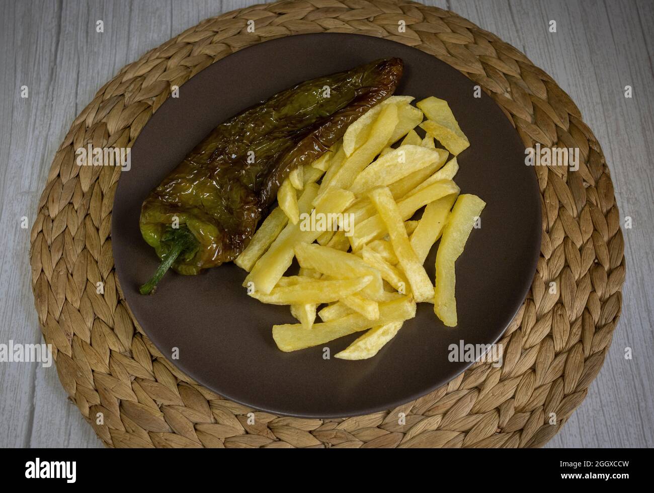Patatine fritte con peperoni fritti, un alimento molto popolare nel sud della Spagna. Le patate non devono essere congelate e tutte fatte in casa. Tutto fatto con olio d'oliva. Foto Stock