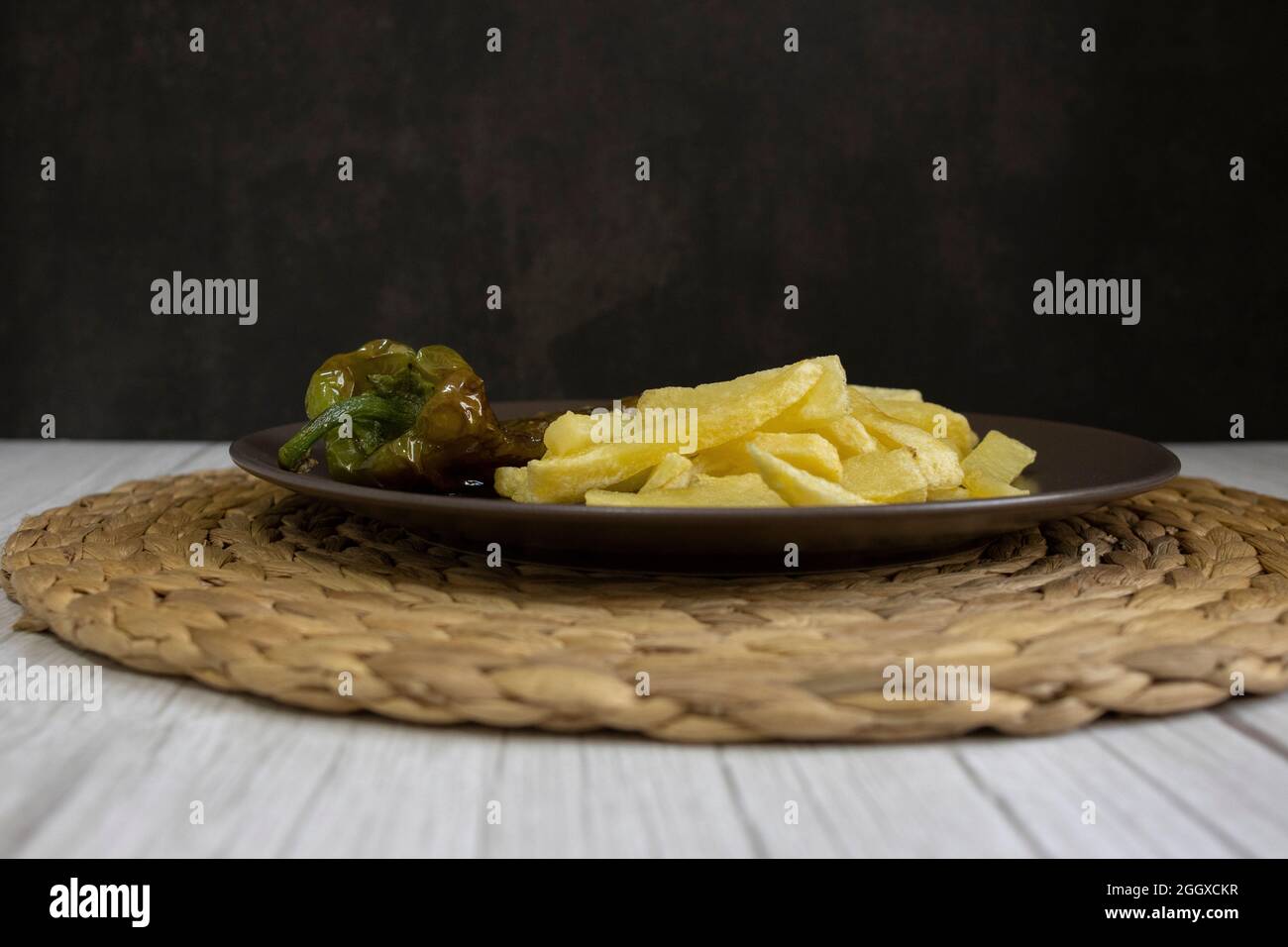 Patatine fritte con peperoni fritti, un alimento molto popolare nel sud della Spagna. Le patate non devono essere congelate e tutte fatte in casa. Tutto fatto con olio d'oliva. Foto Stock