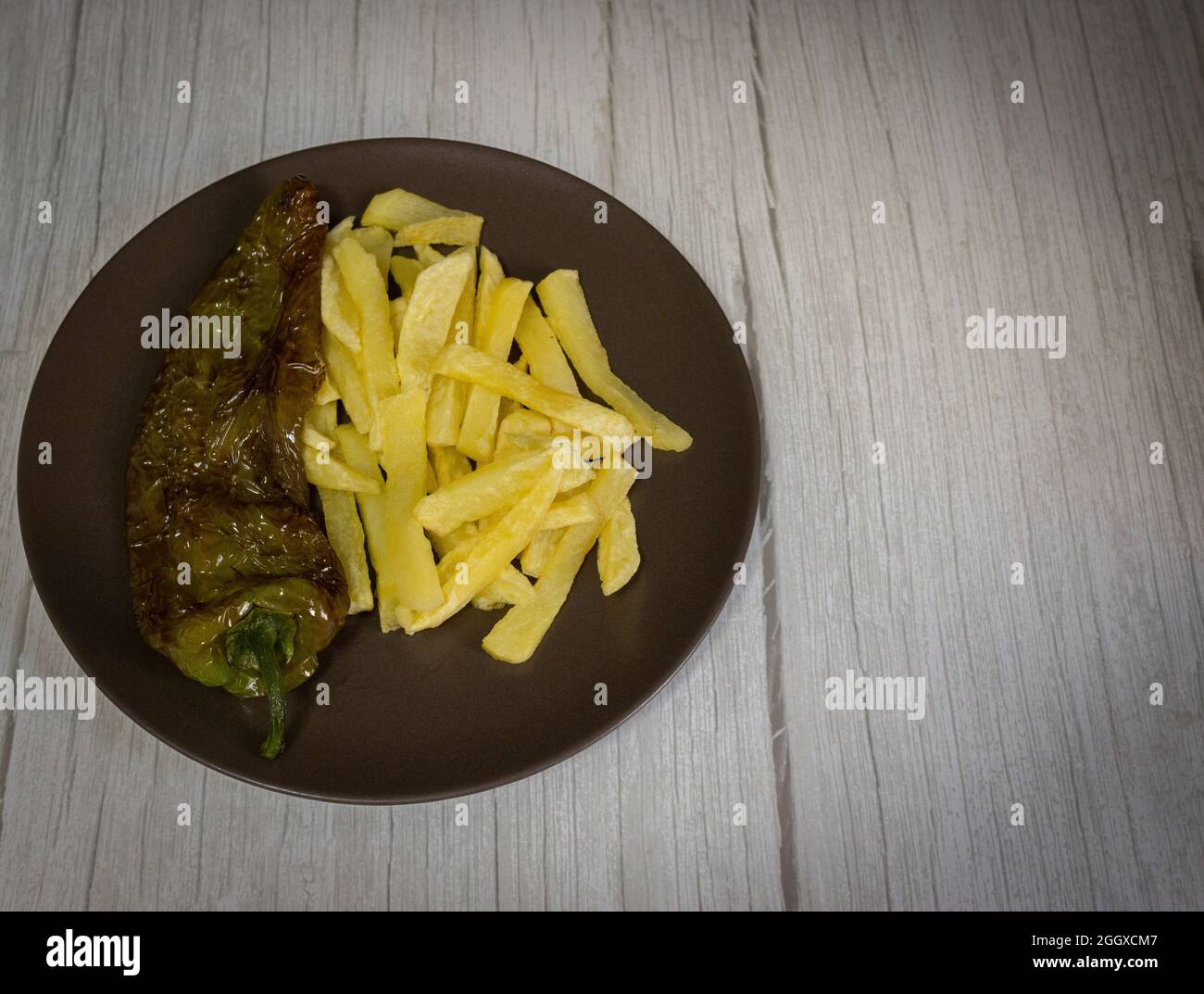 Patatine fritte con peperoni fritti, un alimento molto popolare nel sud della Spagna. Le patate non devono essere congelate e tutte fatte in casa. Tutto fatto con olio d'oliva. Foto Stock