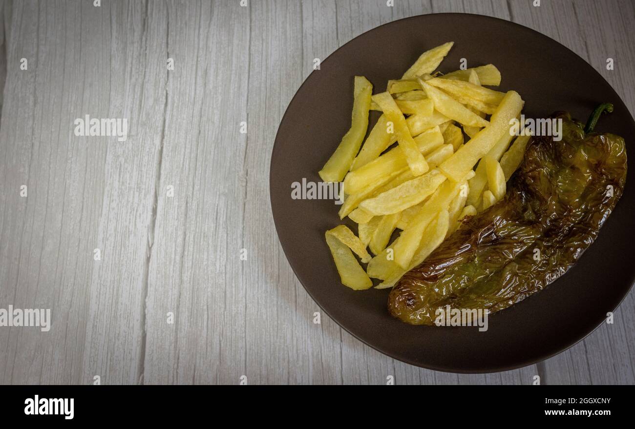 Patatine fritte con peperoni fritti, un alimento molto popolare nel sud della Spagna. Le patate non devono essere congelate e tutte fatte in casa. Tutto fatto con olio d'oliva. Foto Stock