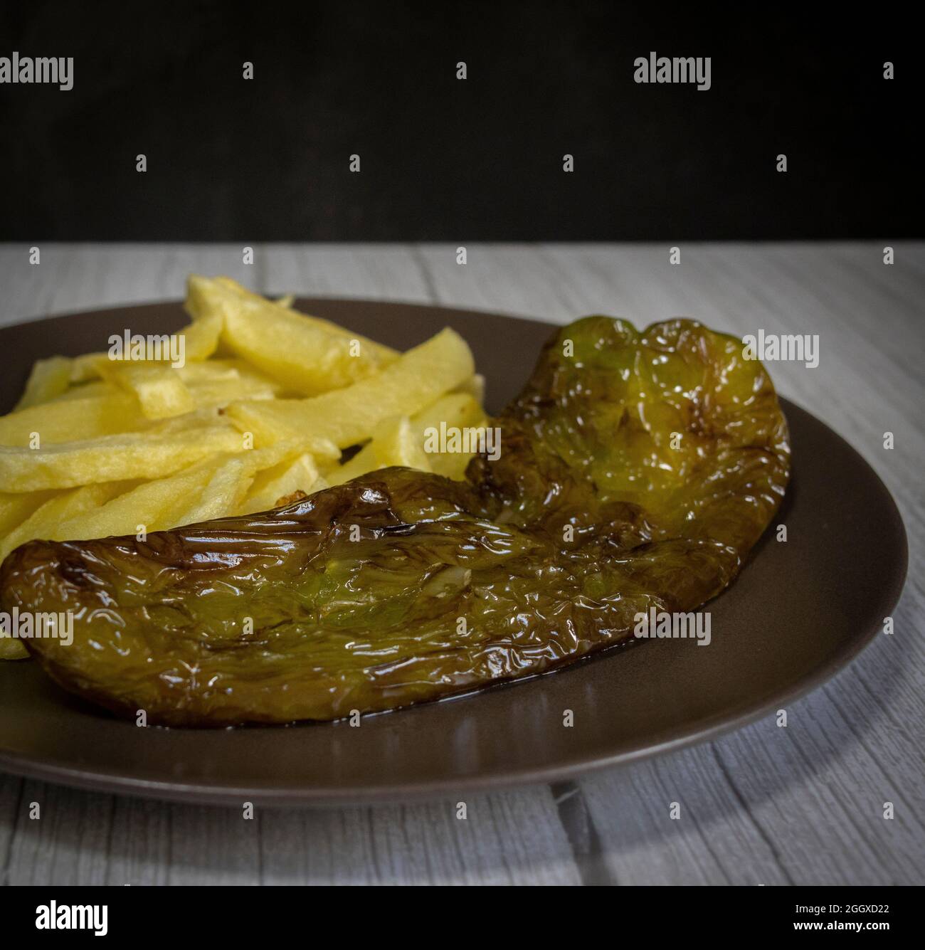 Patatine fritte con peperoni fritti, un alimento molto popolare nel sud della Spagna. Le patate non devono essere congelate e tutte fatte in casa. Tutto fatto con olio d'oliva. Foto Stock