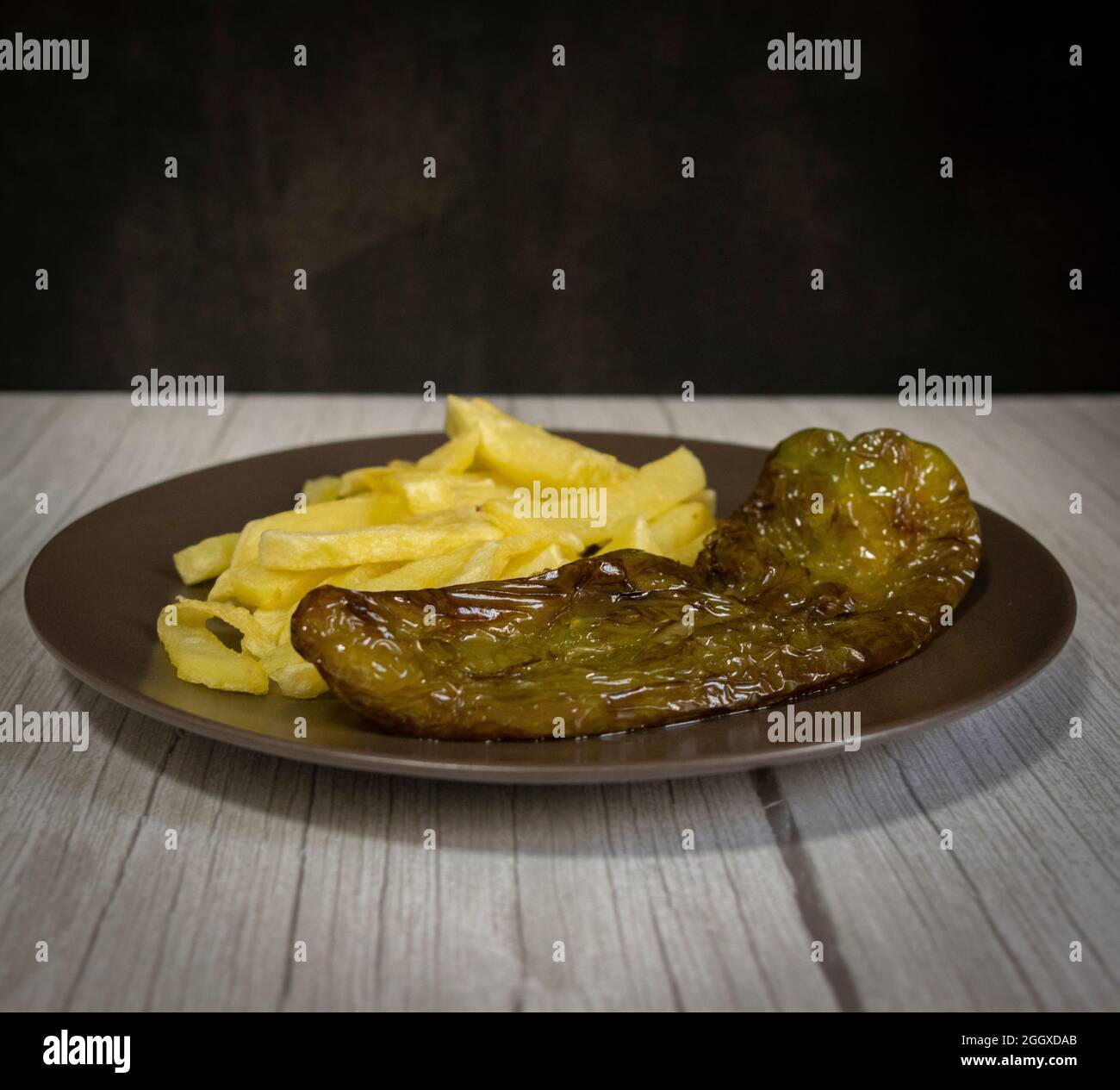 Patatine fritte con peperoni fritti, un alimento molto popolare nel sud della Spagna. Le patate non devono essere congelate e tutte fatte in casa. Tutto fatto con olio d'oliva. Foto Stock