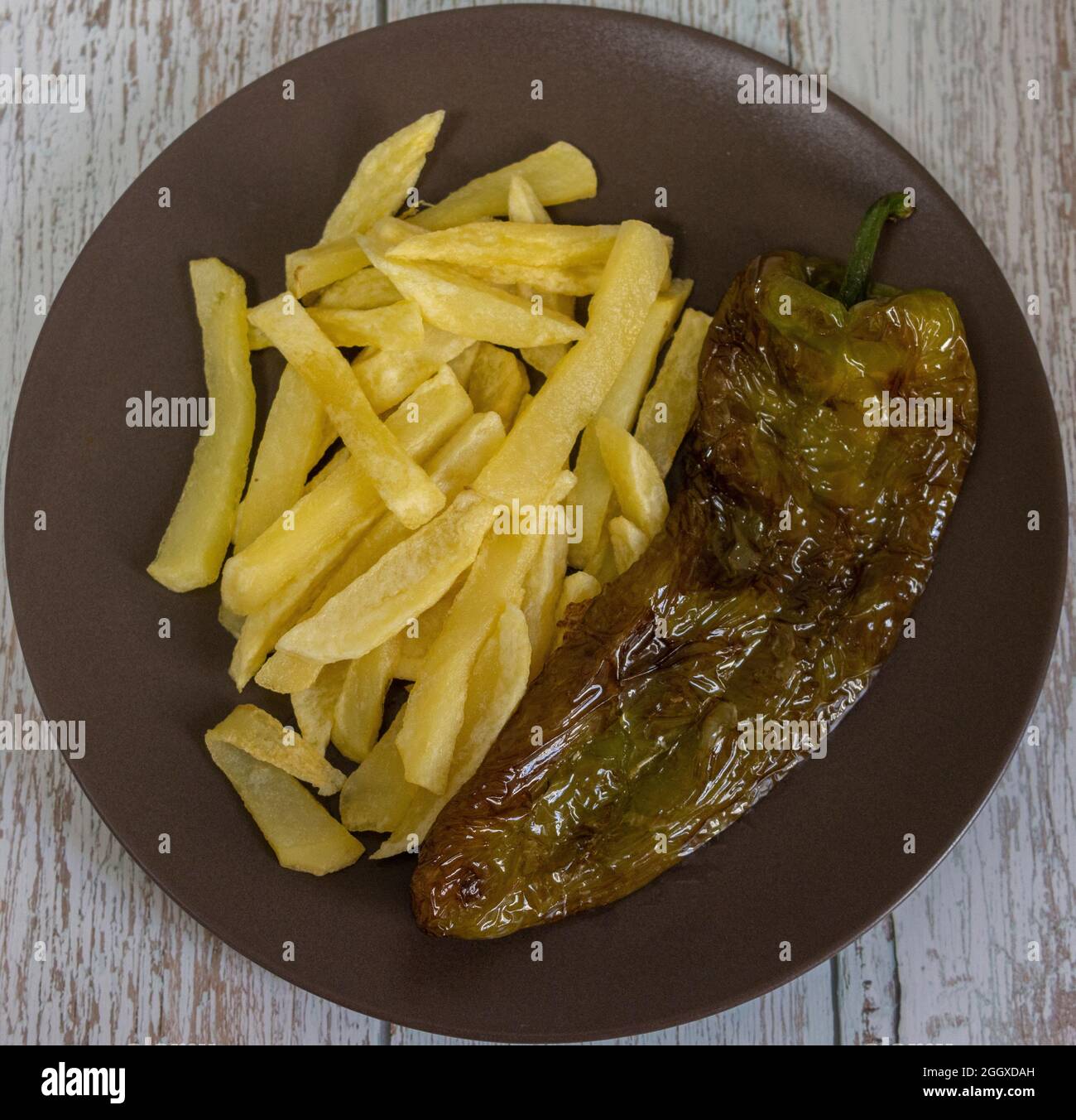 Patatine fritte con peperoni fritti, un alimento molto popolare nel sud della Spagna. Le patate non devono essere congelate e tutte fatte in casa. Tutto fatto con olio d'oliva. Foto Stock
