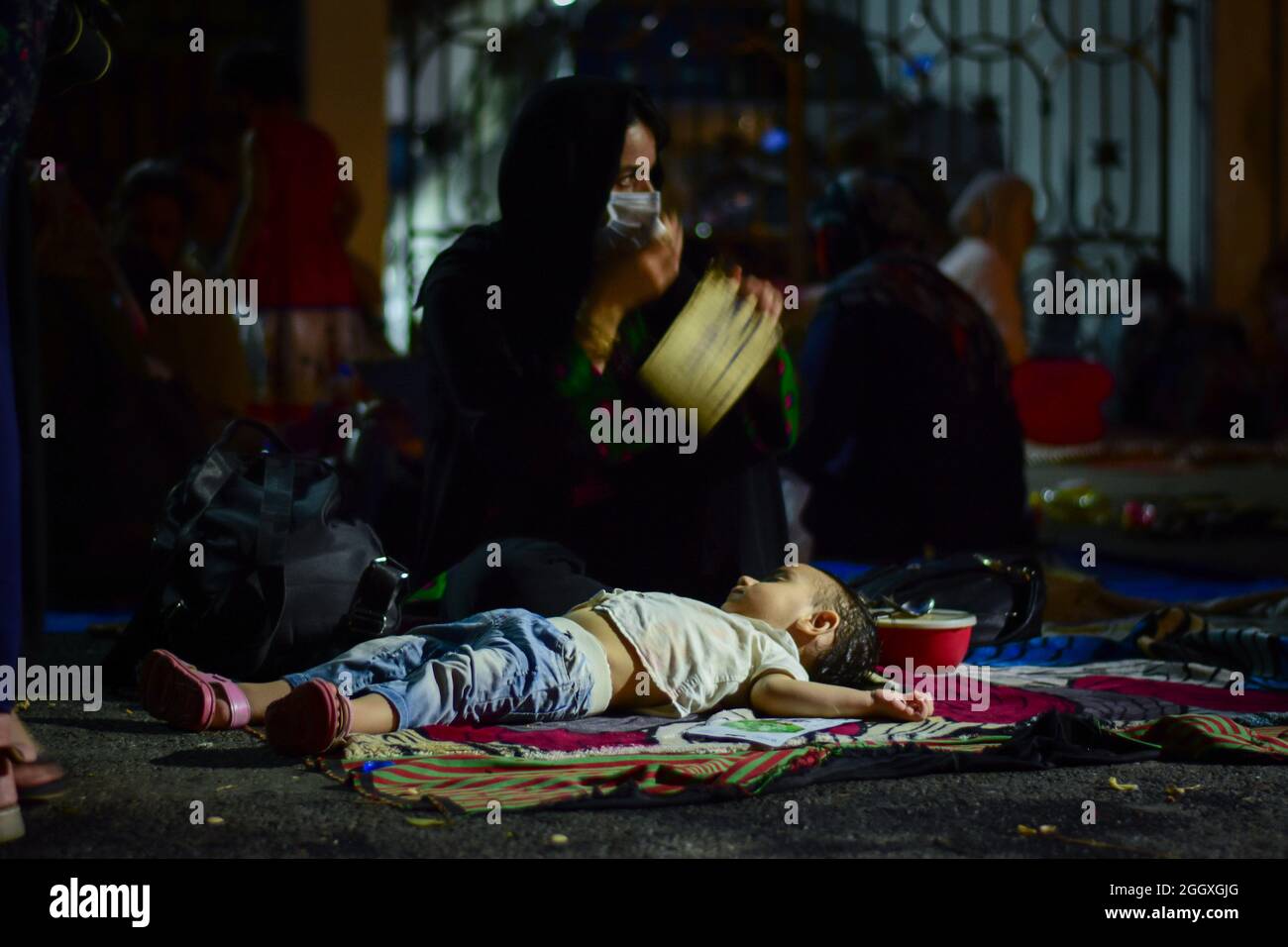 New Delhi, India. 03 Settembre 2021. Una donna con il suo bambino che dorme sulla strada durante la dimostrazione. I cittadini afghani hanno tenuto una protesta al di fuori dell'ufficio dell'Alto Commissariato delle Nazioni Unite per i rifugiati (UNHCR) per sollecitare la comunità internazionale ad aiutare i rifugiati afghani che vivono a Nuova Delhi. Credit: SOPA Images Limited/Alamy Live News Foto Stock