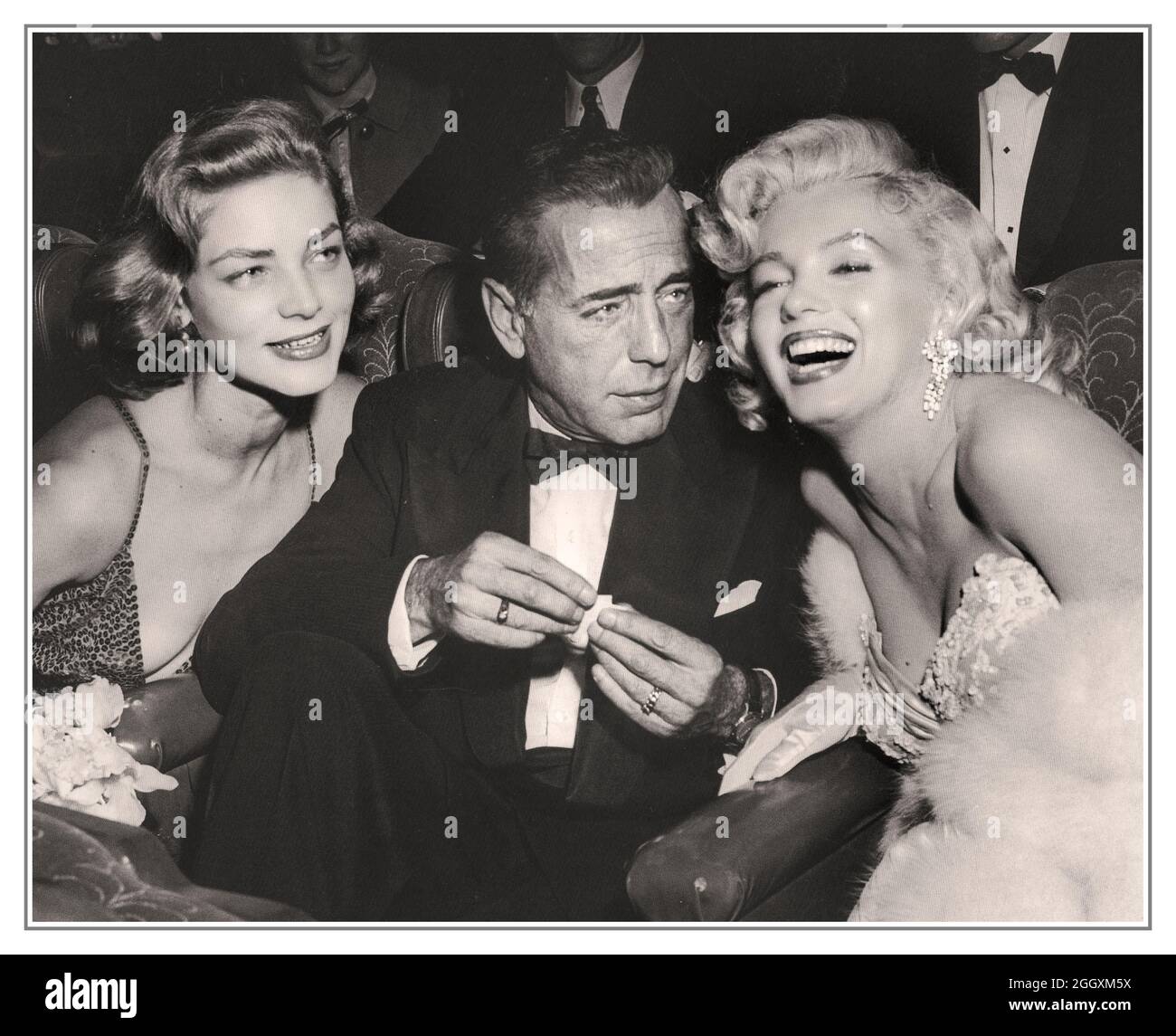Archivio 1953 Marilyn Monroe siede insieme all'attore americano Humphrey Bogart e all'attrice Lauren Bacall, preso al nightclub di Ciro a Los Angeles USA Hollywood Movie Star Photos B&W Foto Stock
