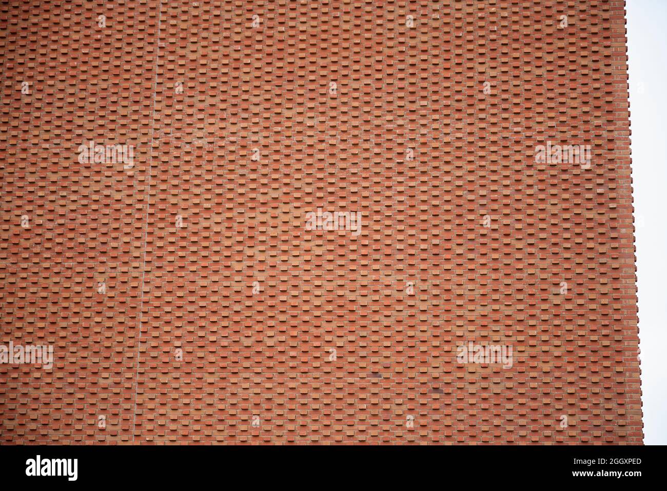 Una moderna struttura architettonica in mattoni rossi con struttura o struttura costruita a causa del posizionamento dei mattoni. Foto Stock